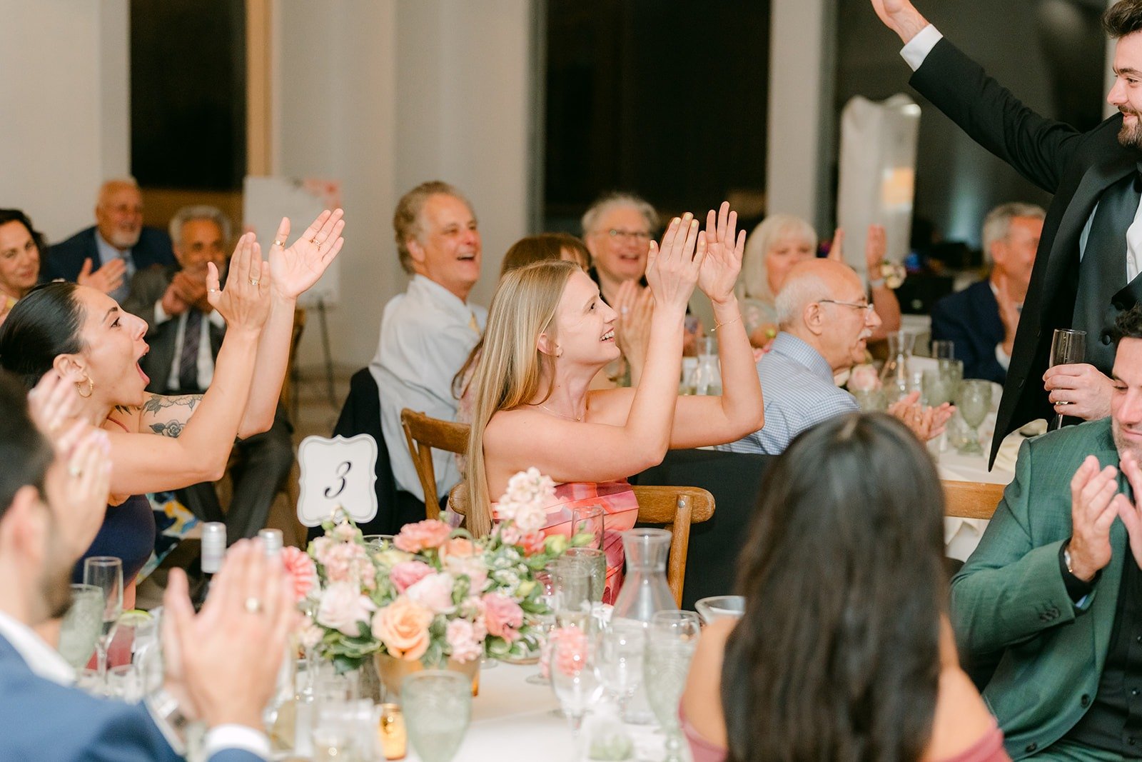Guests raising their hands and cheering during the toasts