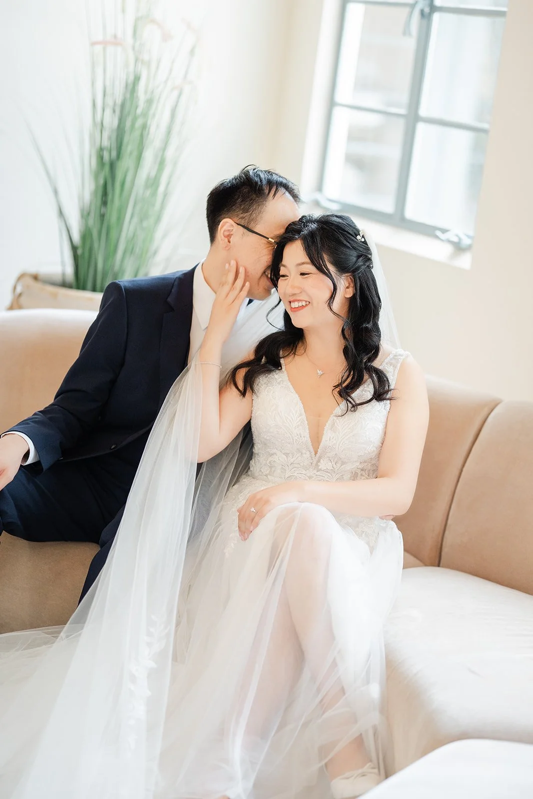 Lawrence kissing Constance's cheek on a cream sofa