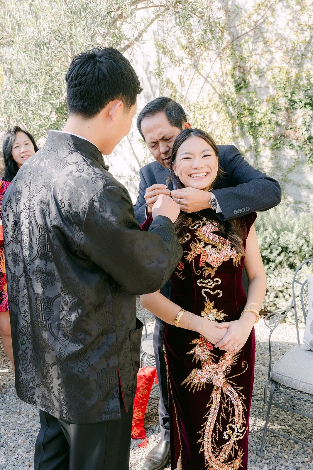 Richard and Jadee sharing a hug with a family member during the tea ceremony