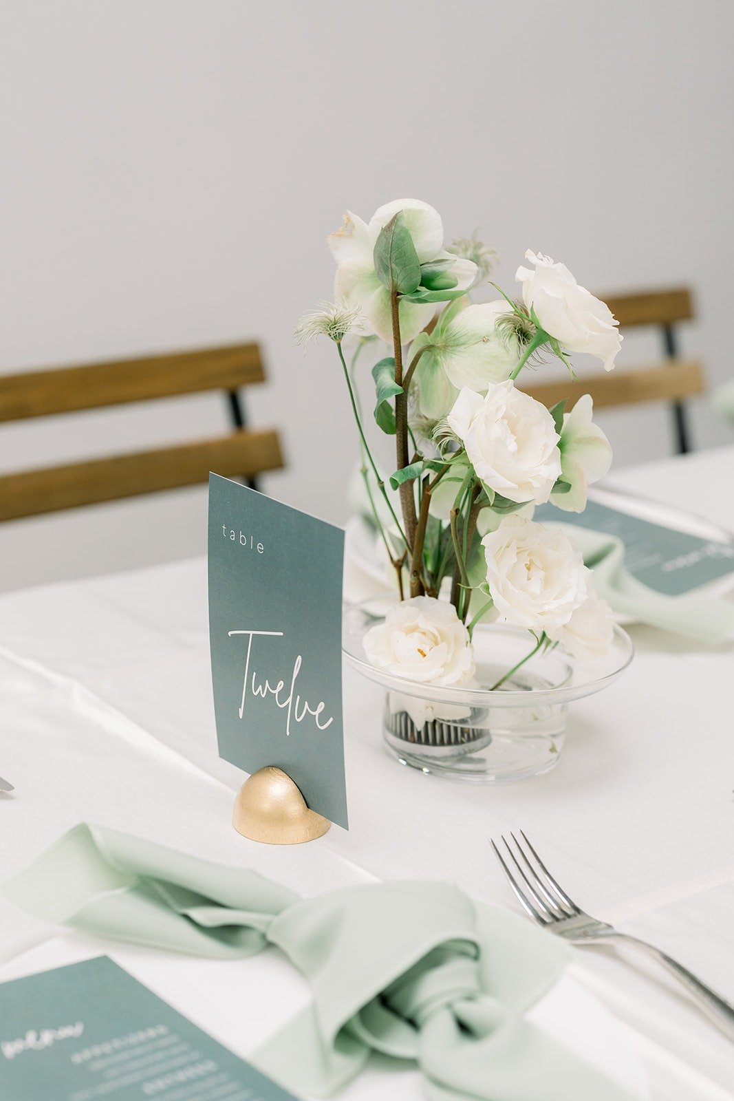 Place setting with a sage napkin and white florals