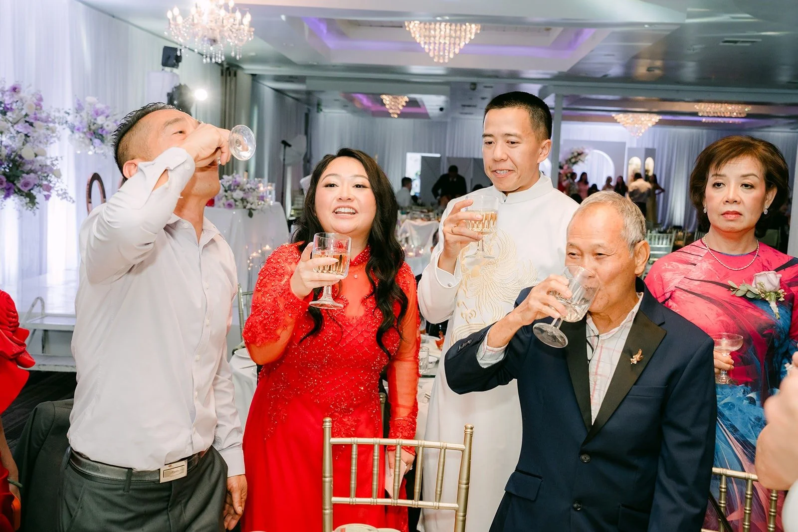 Guests raise their glasses with Jennifer and Kevin at a table, photographed by One and Only Production