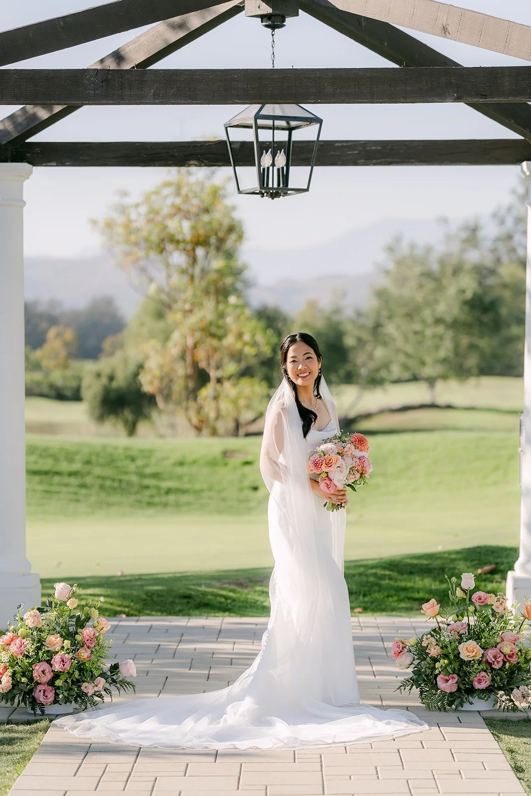 Stephanie in her gown and veil framed by the pagoda beams and hanging lantern