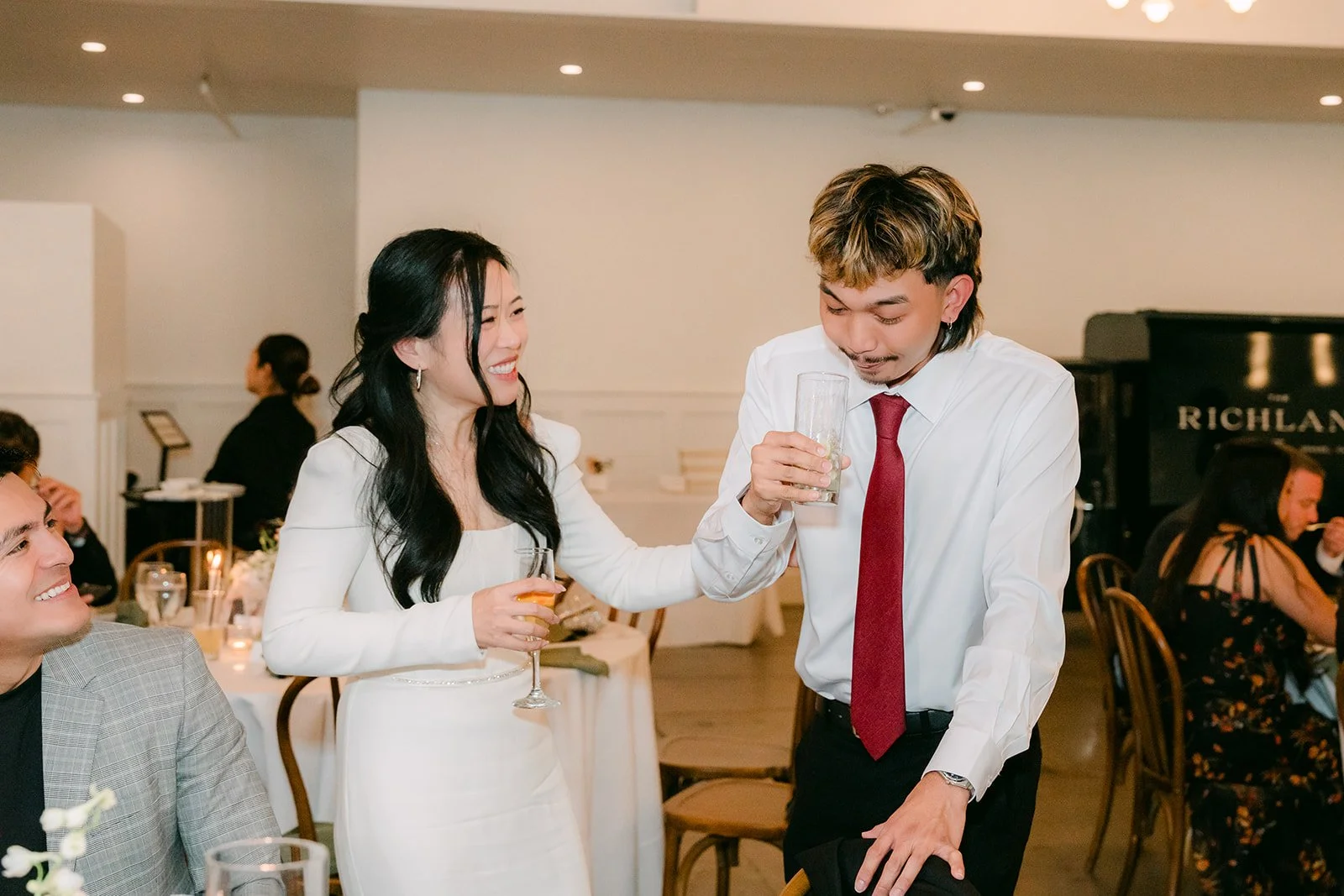 Denise and a groomsman laughing over their shots.