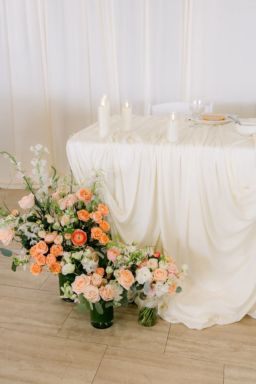 Florals beside a draped table at the reception