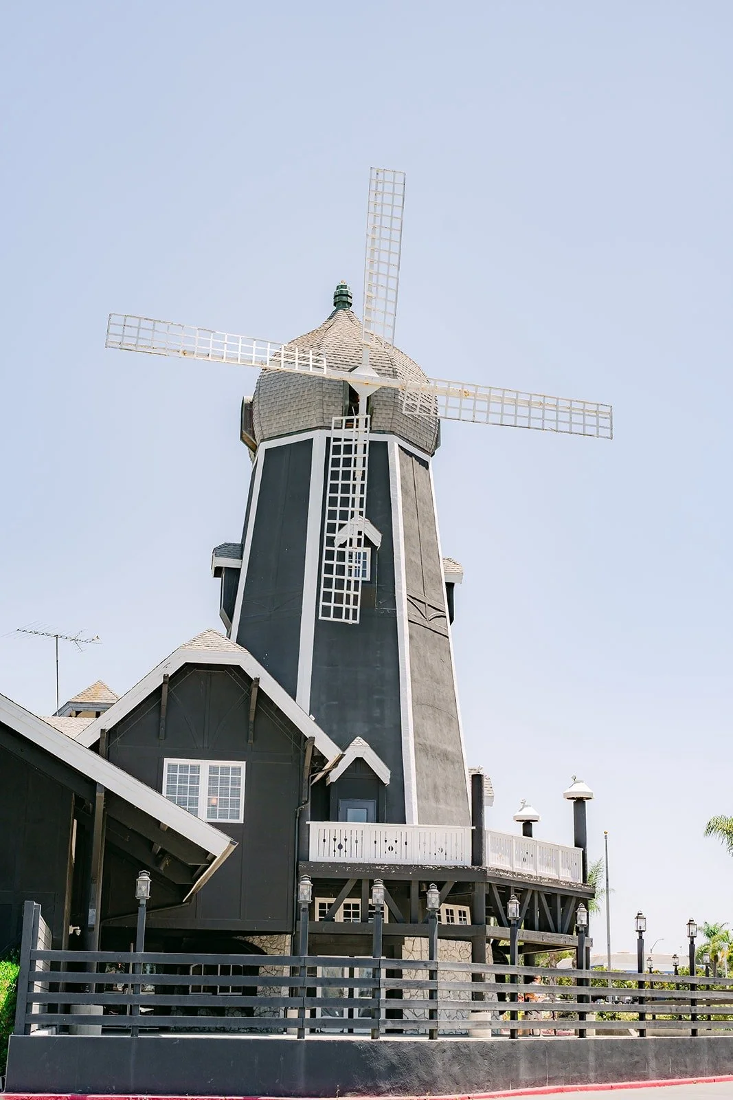 The black windmill tower against a blue sky