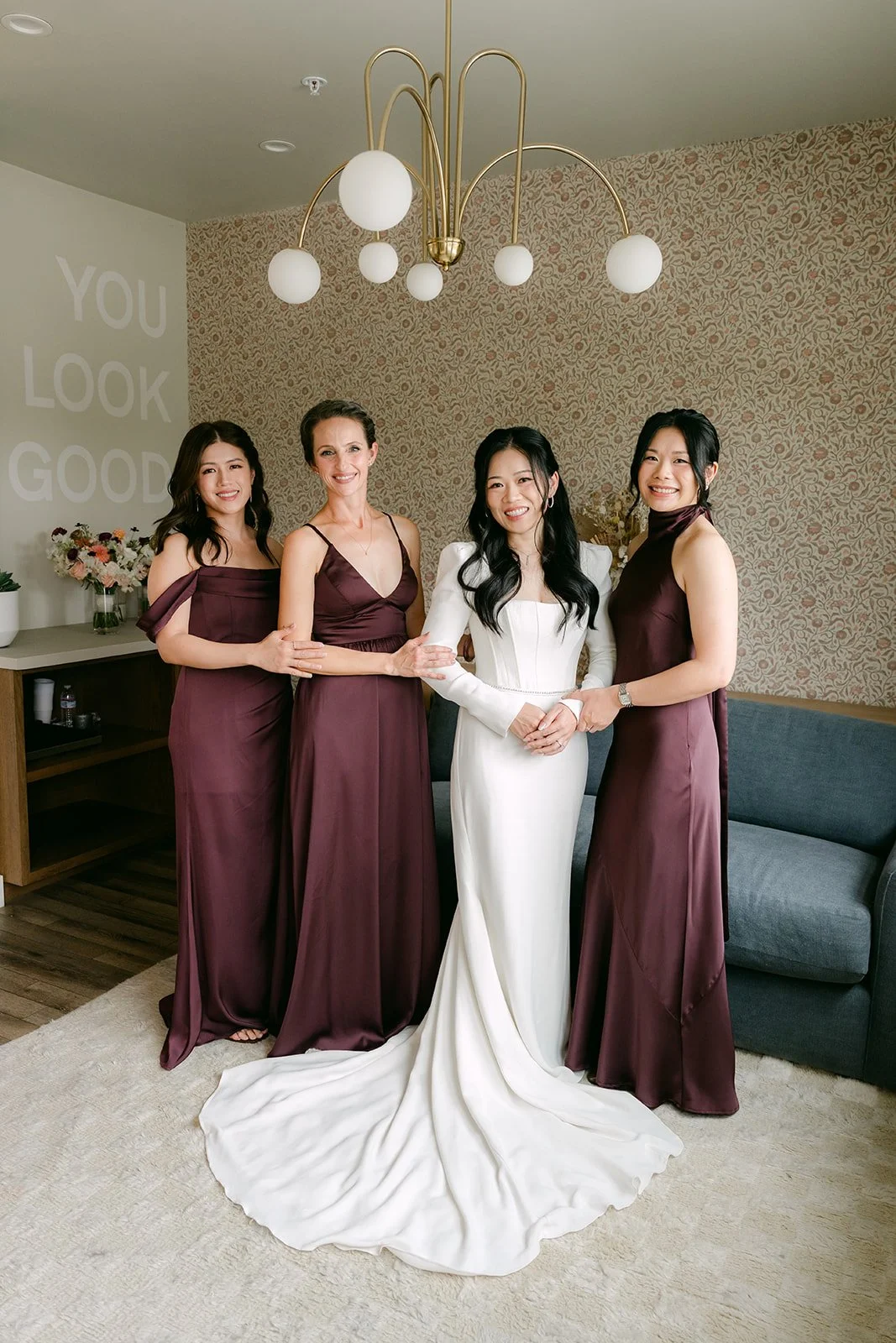 Denise with her three bridesmaids in burgundy satin dresses.