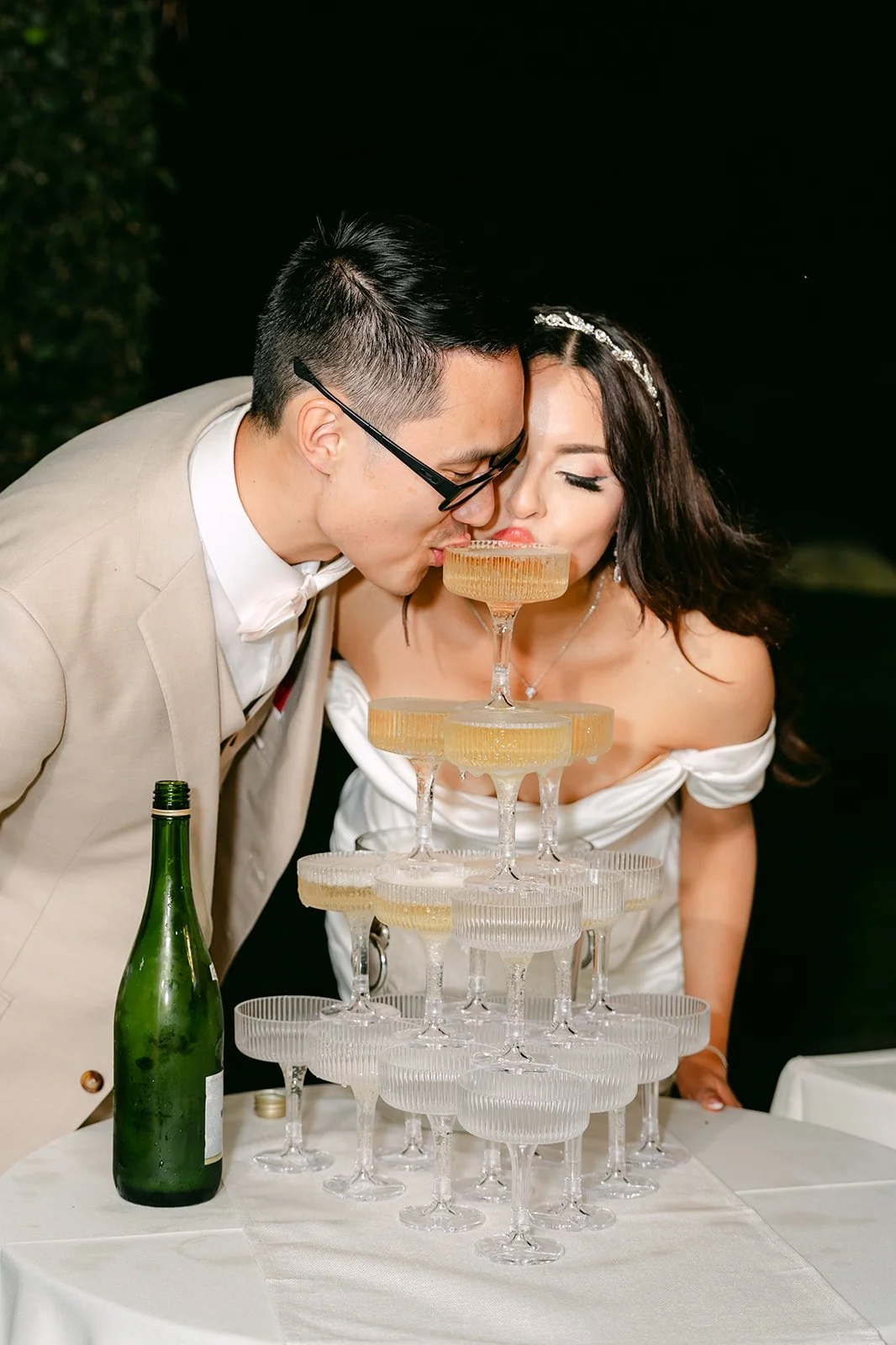 Kevin kissing Sandra as they pour the champagne tower.