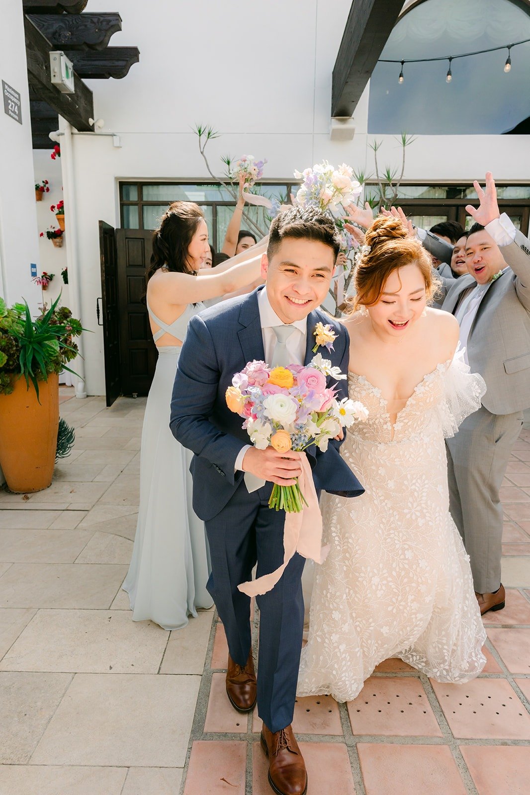 Jerrick leading Joanna through the cheering wedding party