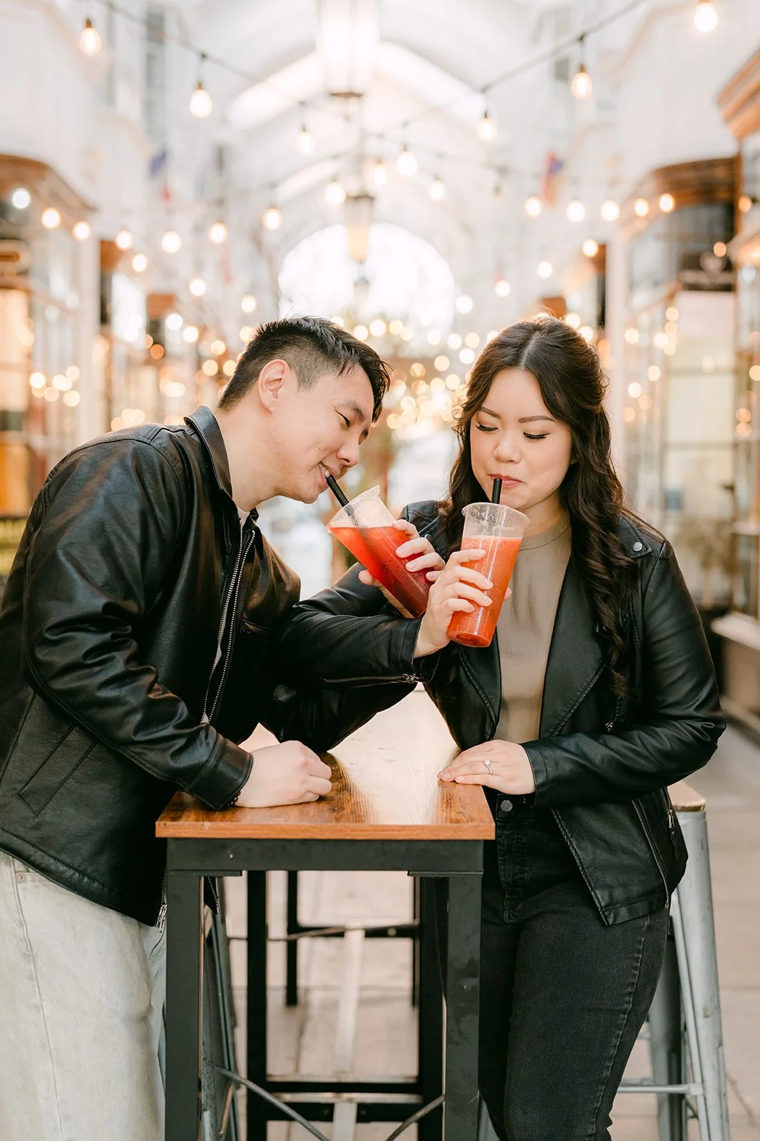 James leans in toward Emily as they sip their drinks.