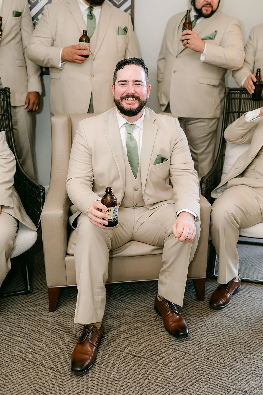 Cody laughing with his groomsmen in the hotel suite.