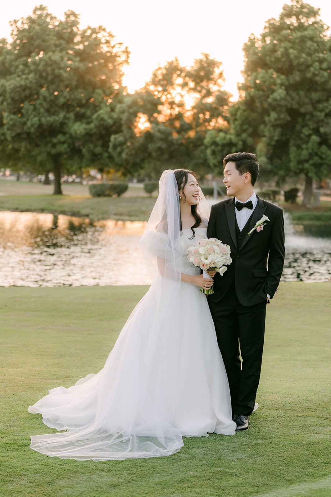 Jeannie and Eunsang standing by the lake on the fairway