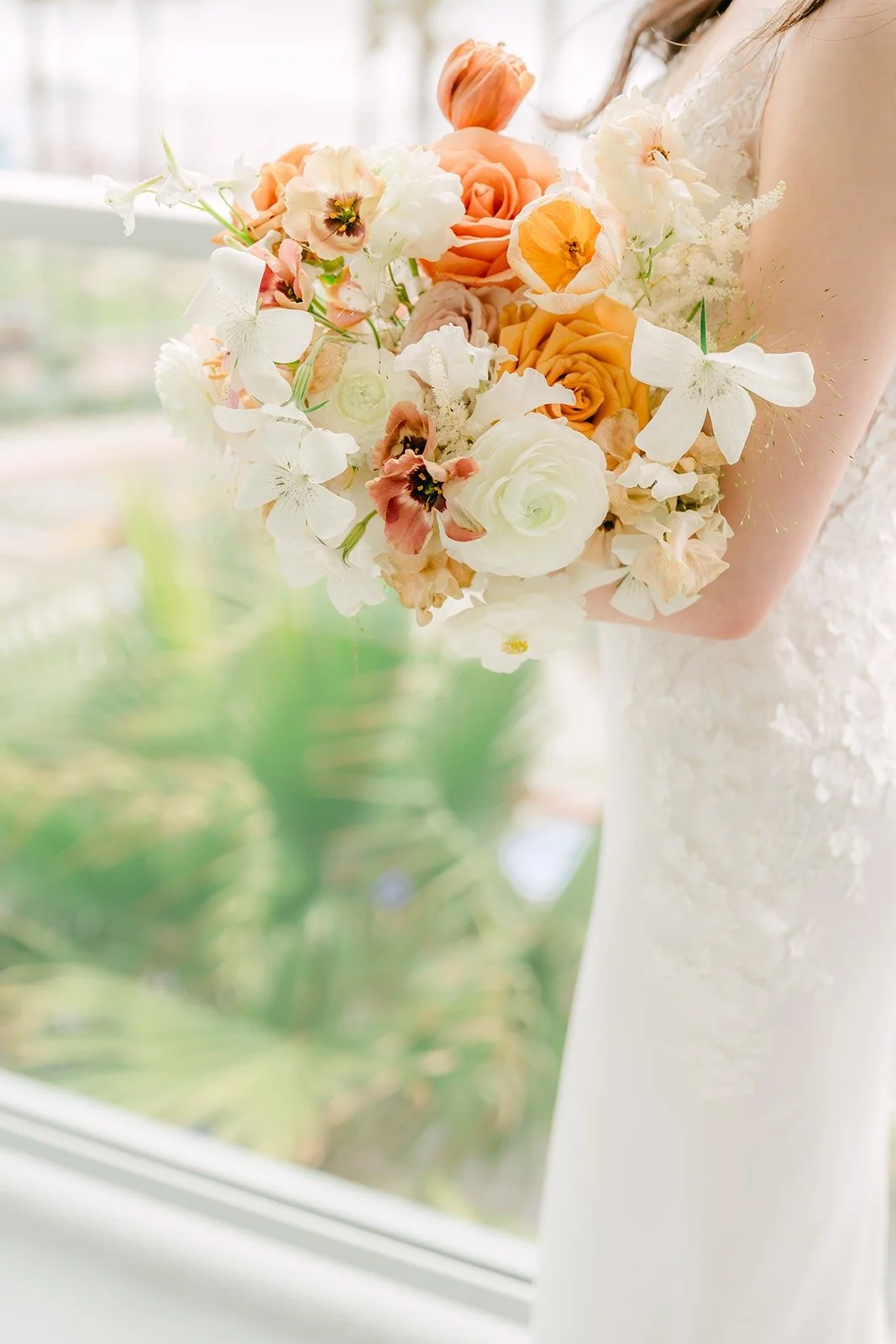 Close up of Angela's bouquet of peach roses and ivory blooms