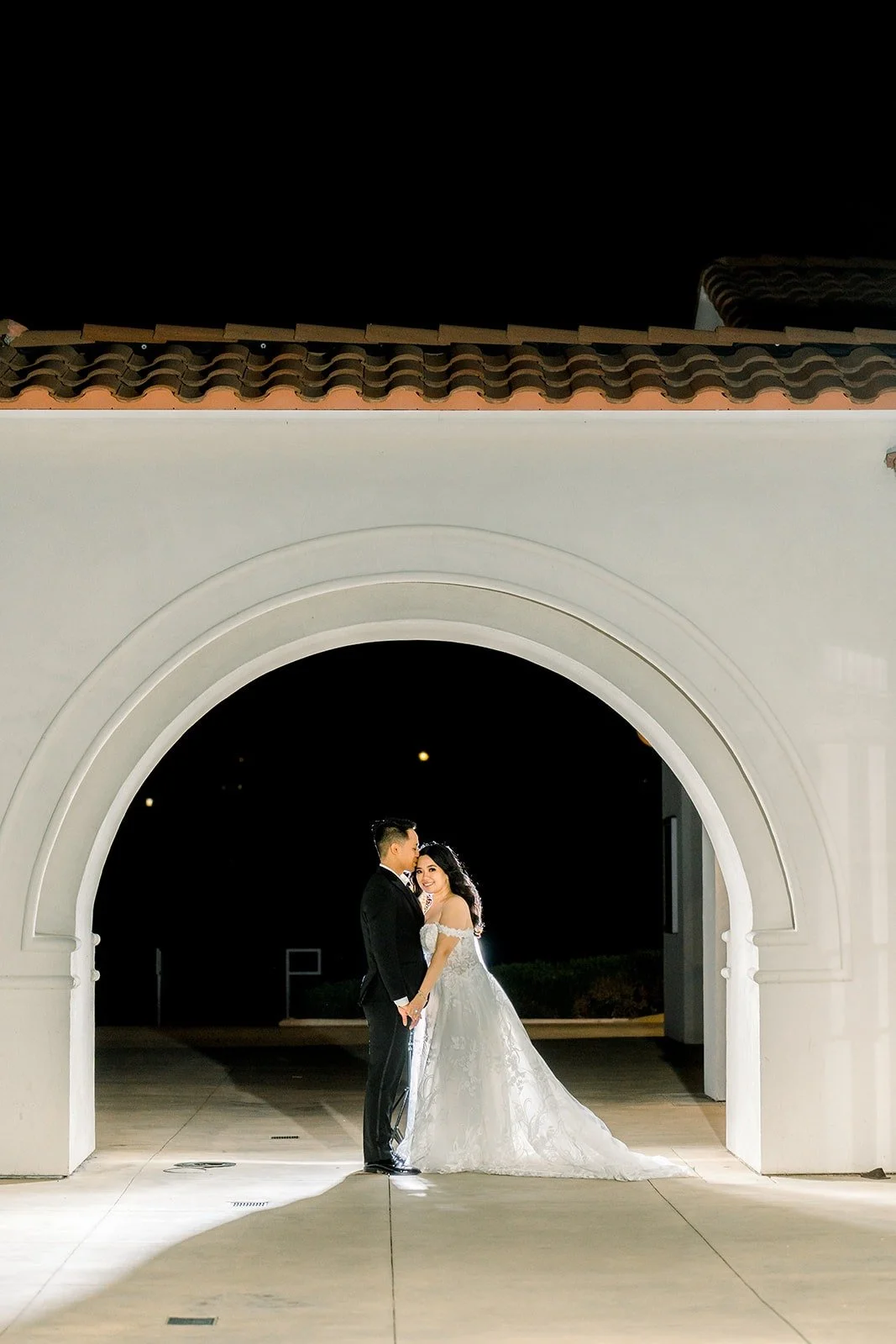 Francesca and Ralph under a lit archway at night, photographed by One and Only Production