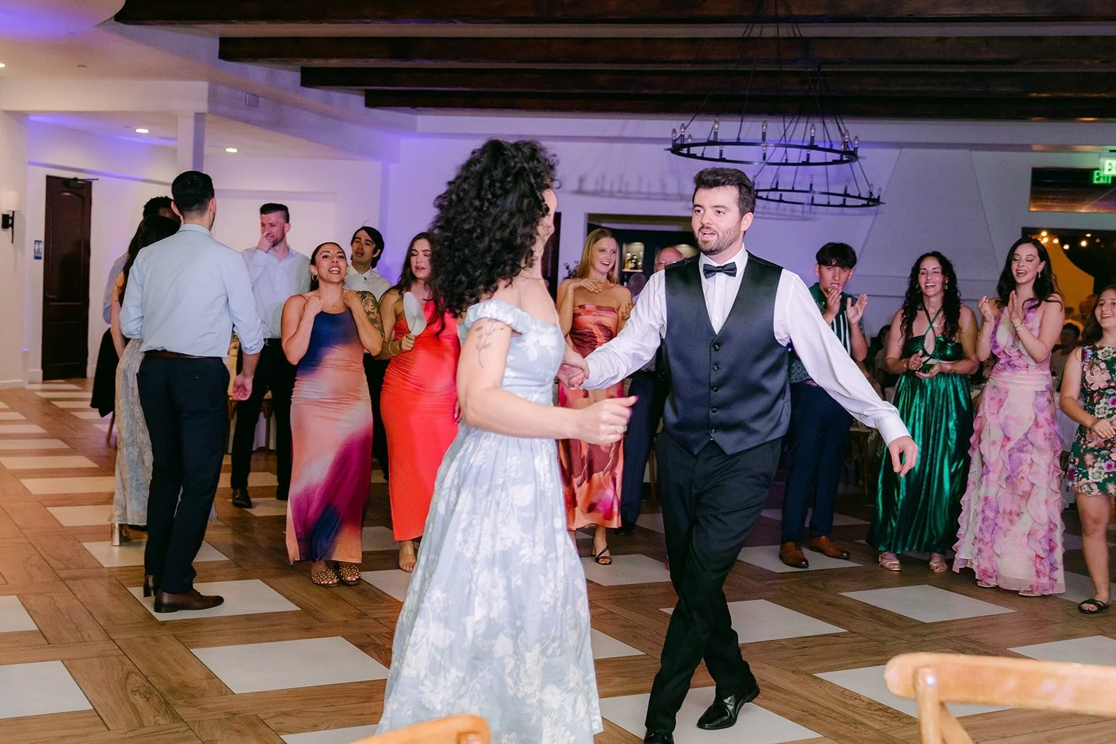 Stephanie and Kevin dancing in front of guests under purple uplighting