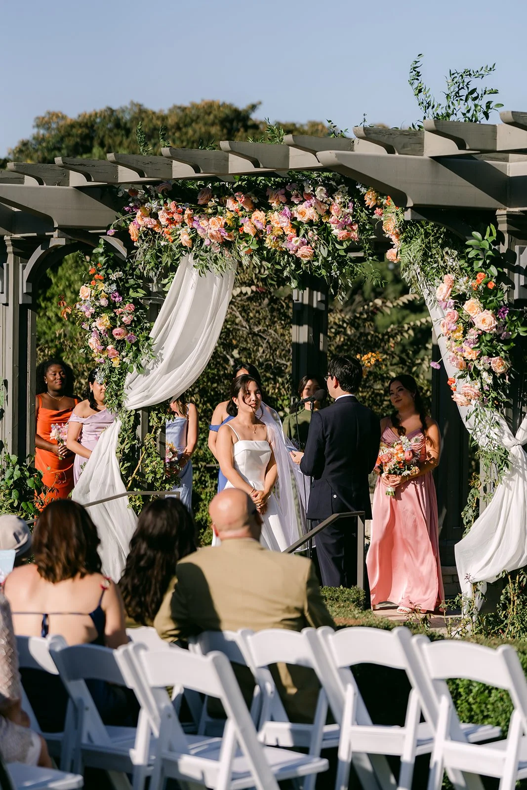 The ceremony under the flower-draped pergola at South Coast Botanic Garden
