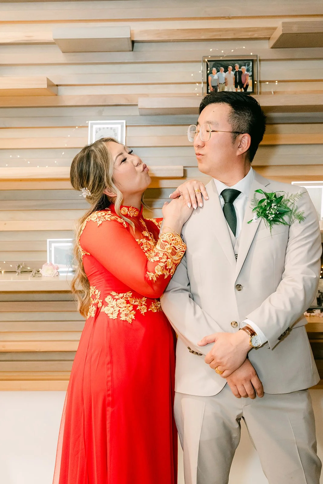 Bride in red and gold leaning on the groom's shoulder