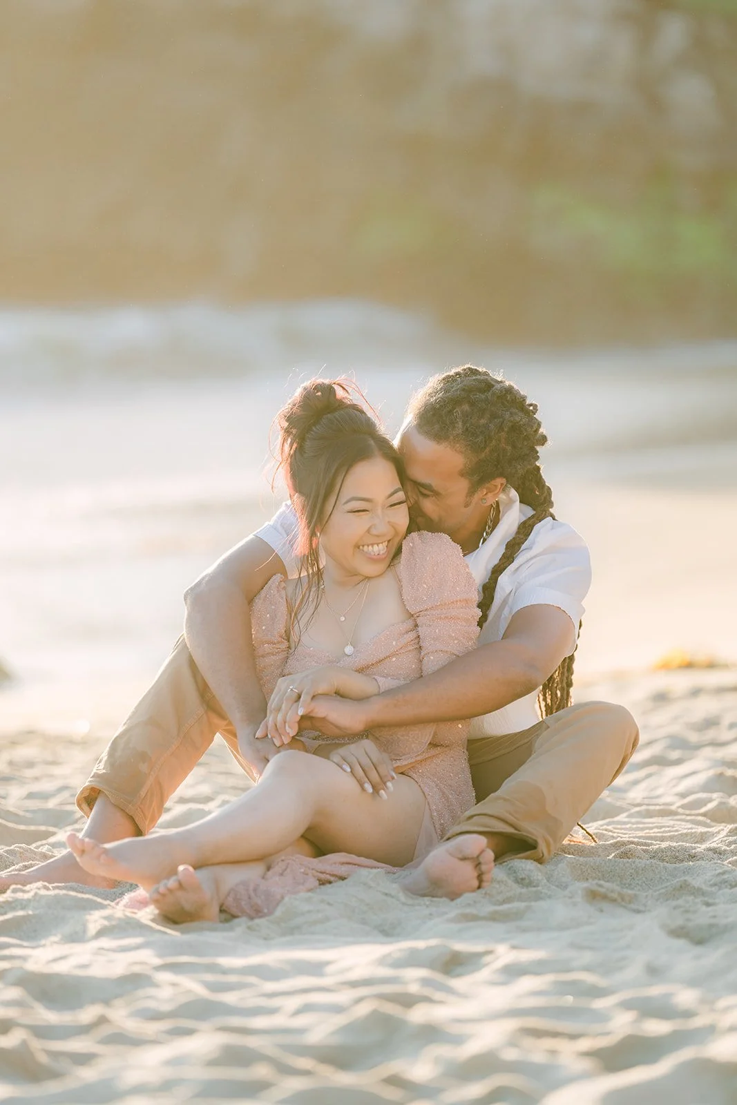 Amy and Michael sitting together on the sand.