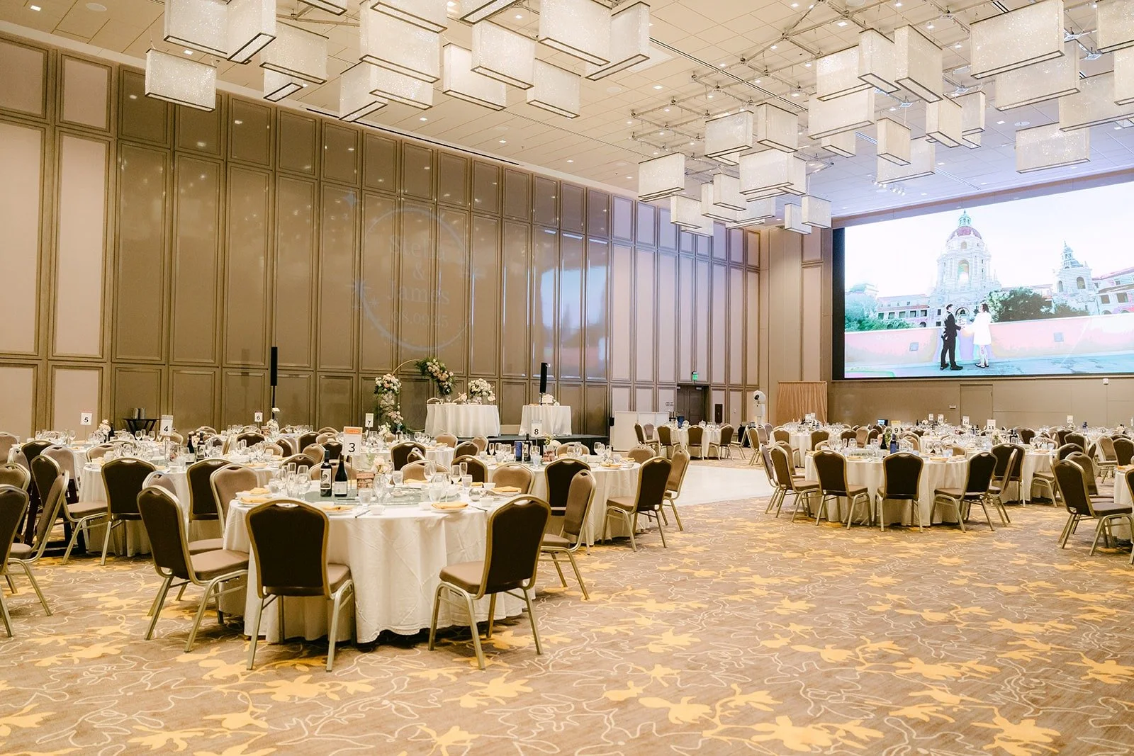 A wide view of the reception tables and gold chairs in the Sheraton ballroom