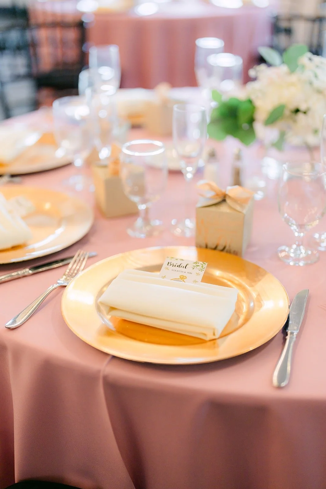 Reception table set with gold chargers and pink tablecloths