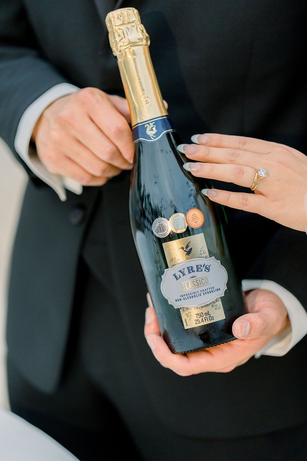Steven and Jacinda hold a bottle of champagne