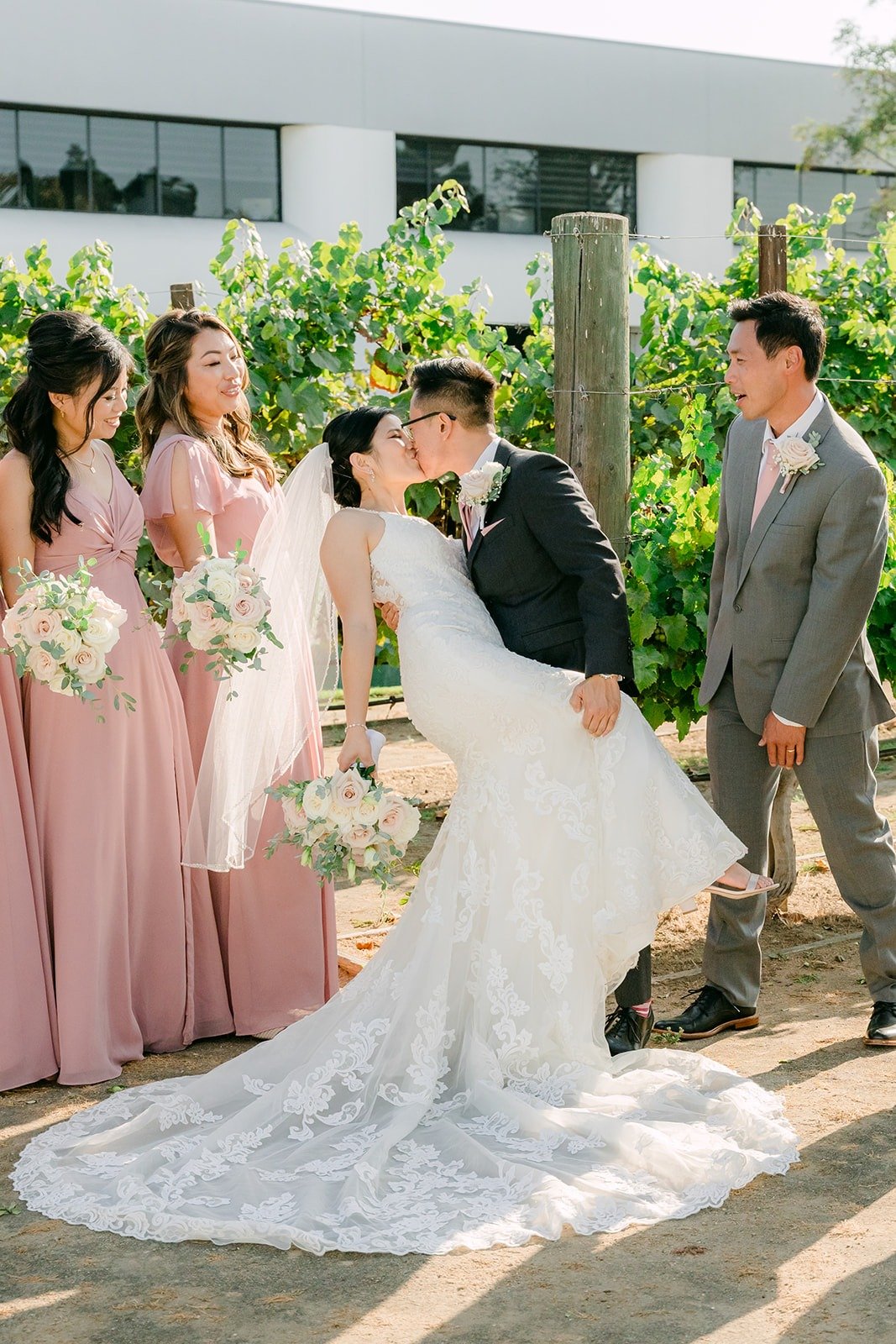 Alex dipping Xuemin for a kiss with the wedding party around them