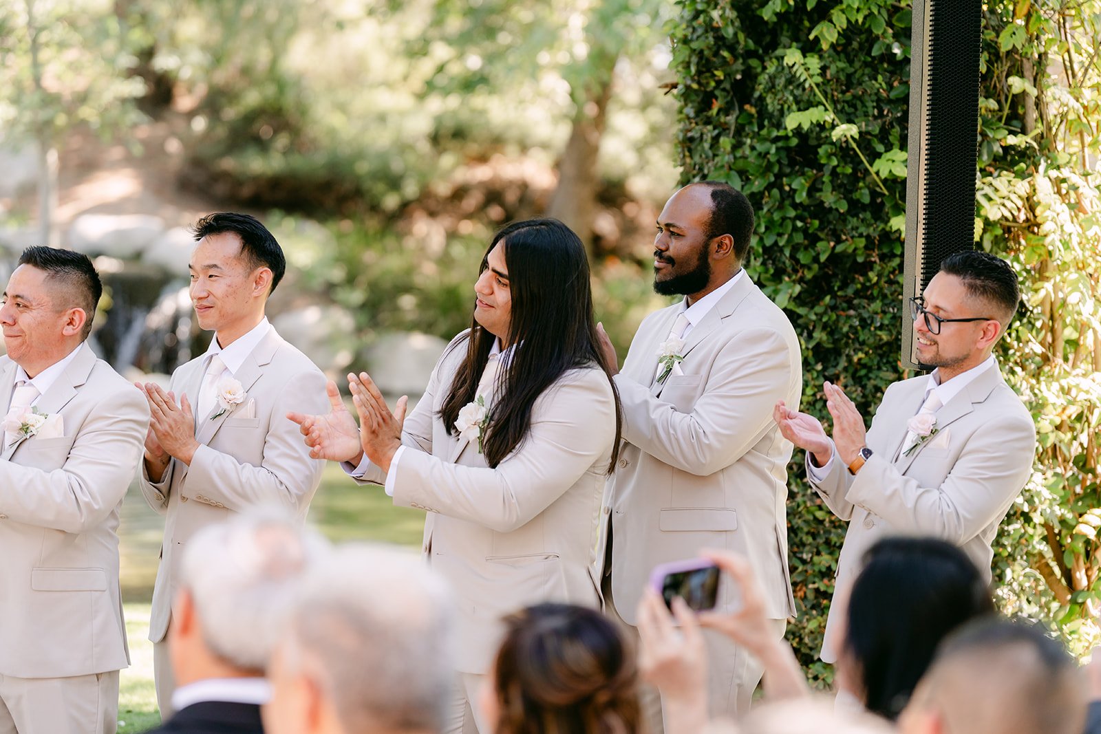 Groomsmen clapping as Sandra and Kevin are pronounced married.