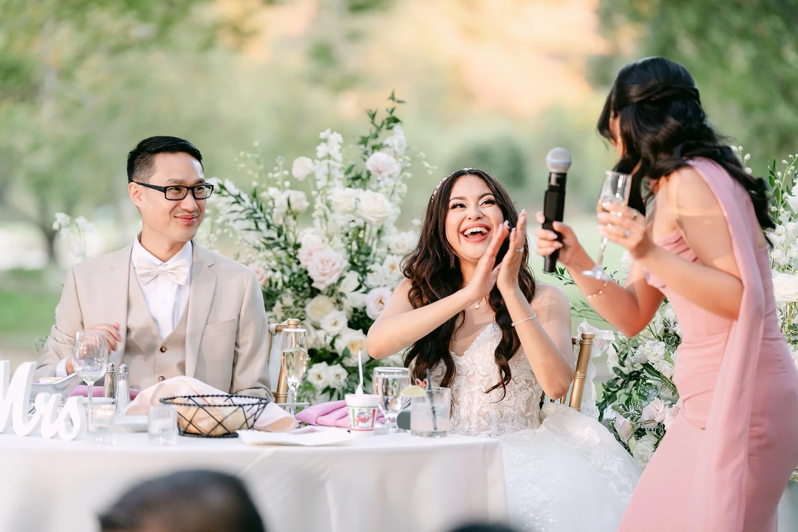 Sandra laughing as her maid of honor shares a story.
