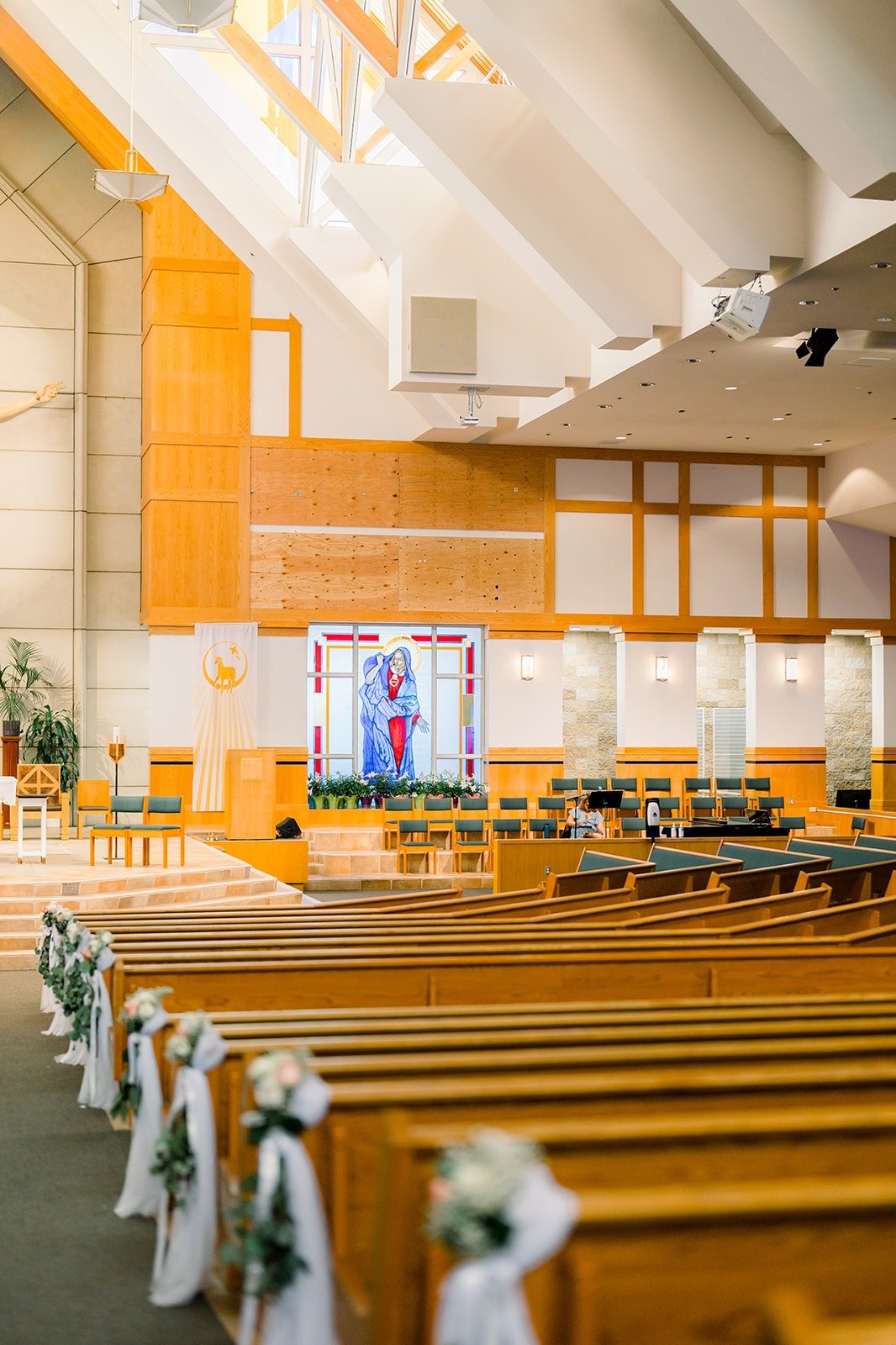 White florals lining the pews inside St. Paul the Apostle Catholic Church