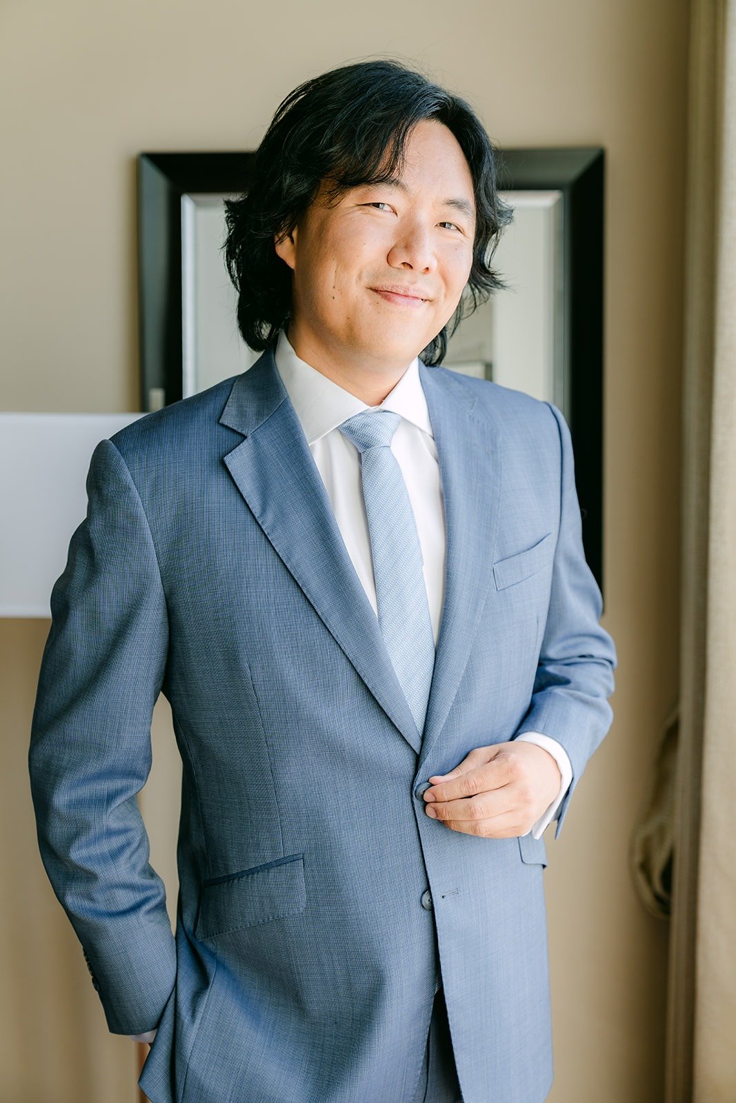 Philip in his light blue suit by the hotel window