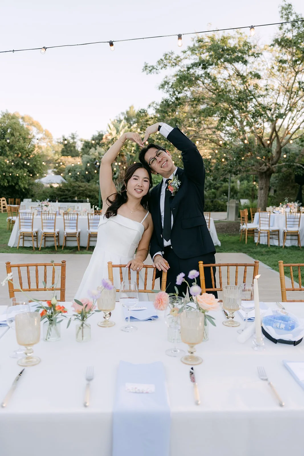 Saya and Leroy celebrating beside the reception tables