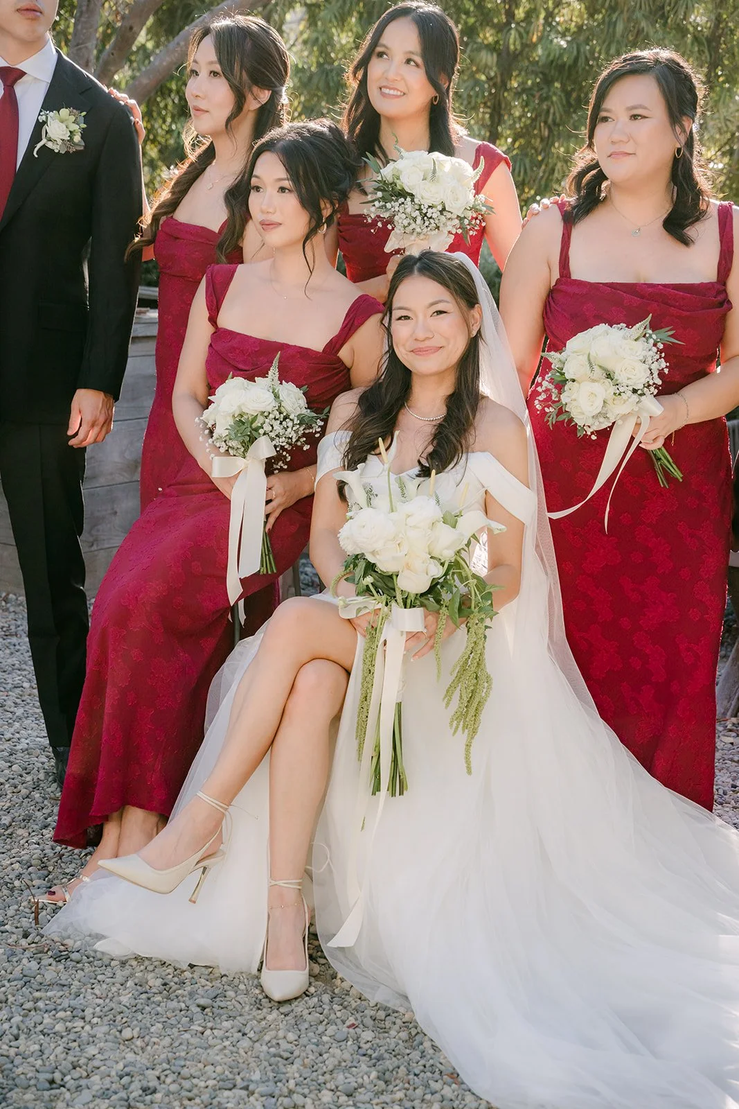 Jadee seated with her bridesmaids in burgundy