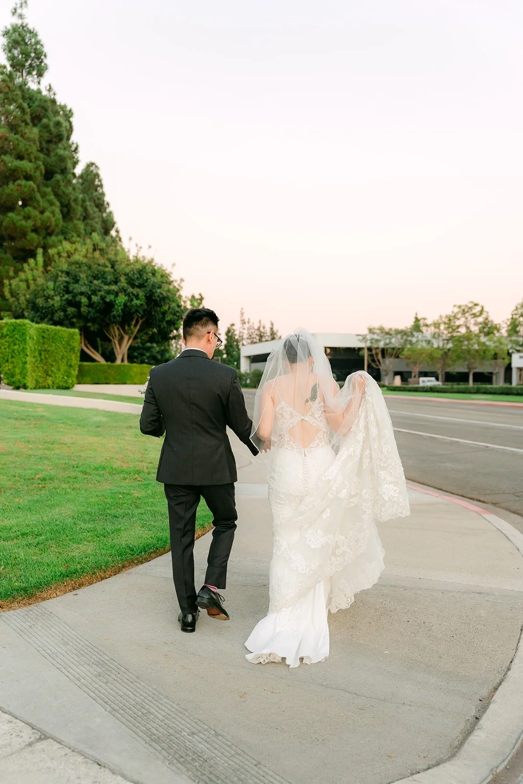 Xuemin and Alex walking back across the lawn after sunset, photographed by One and Only Production