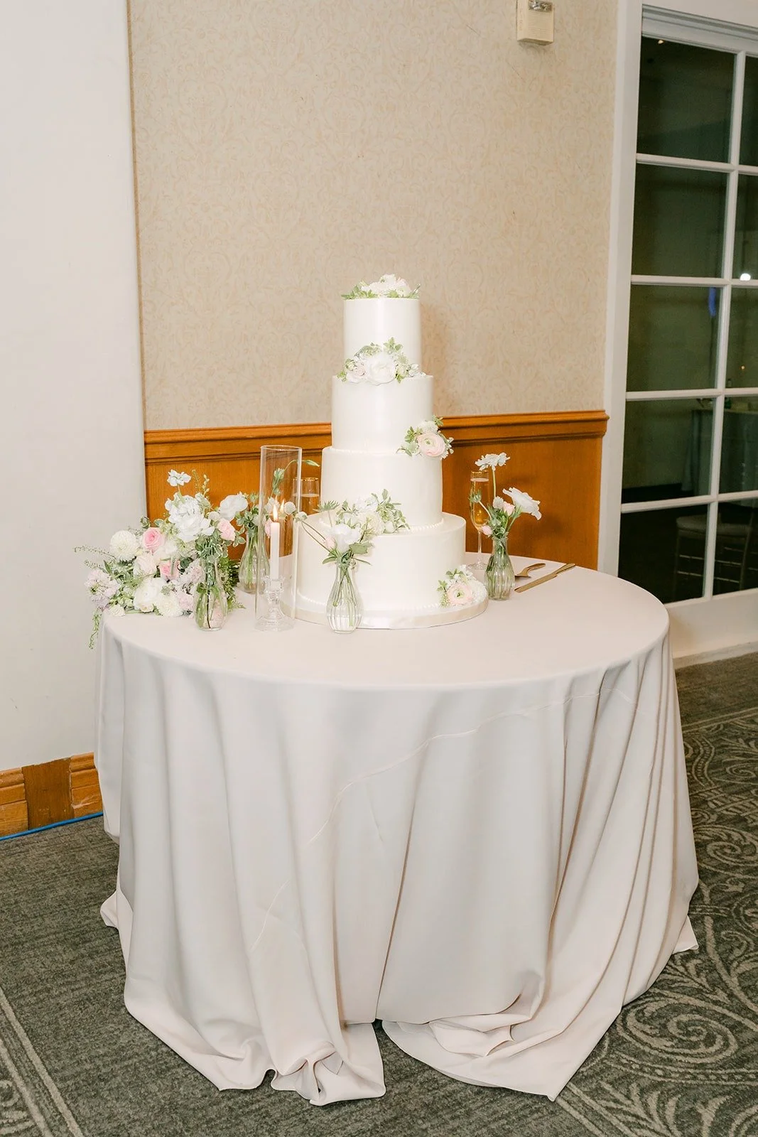 The white tiered wedding cake on a round table