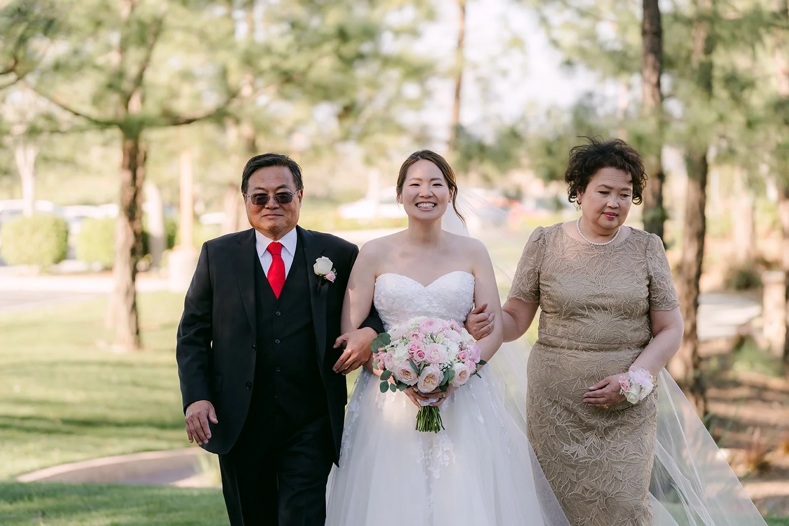 Victoria walking down the aisle on the lawn with her parents