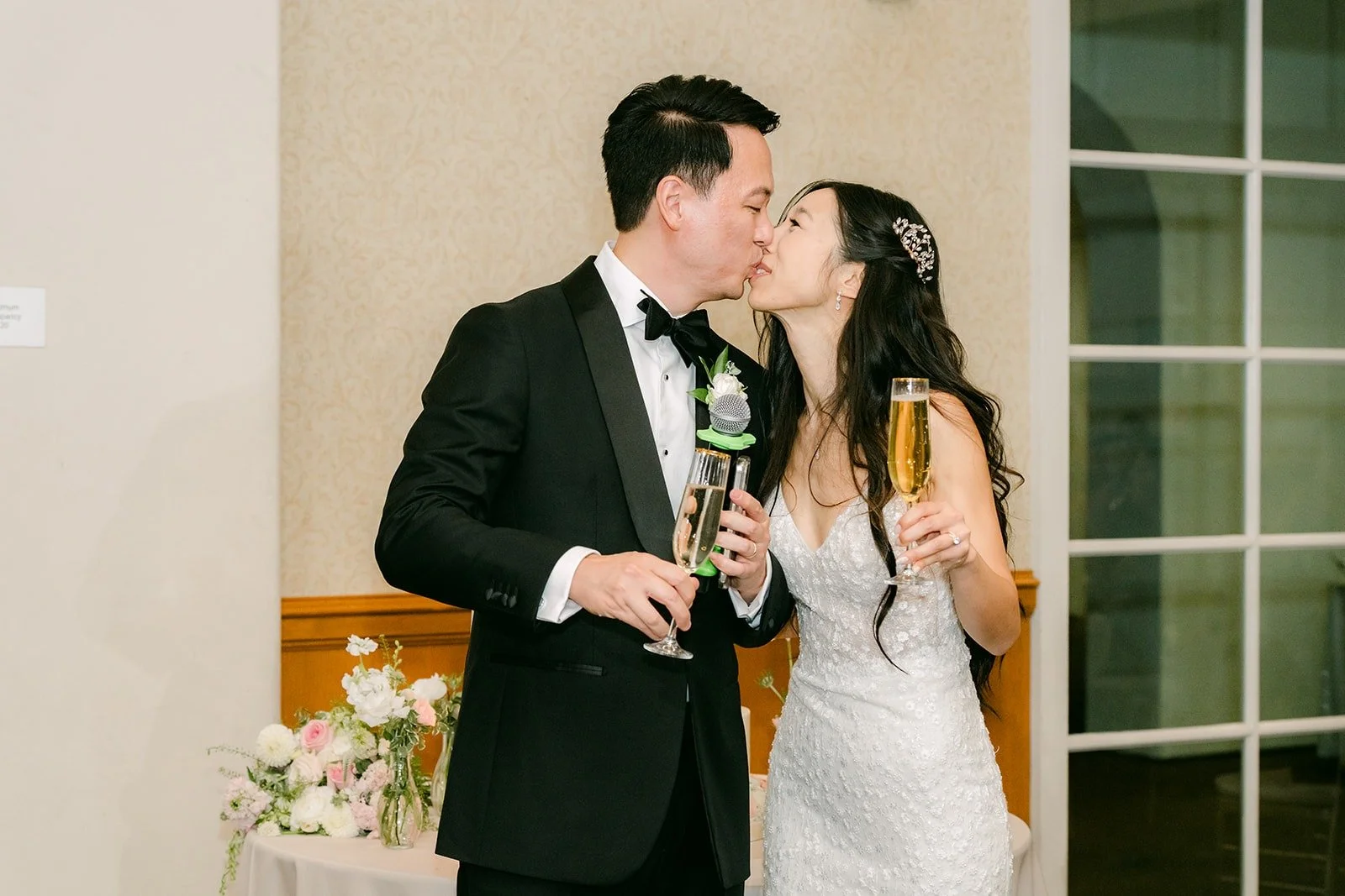 Kristine and William sharing a kiss after cutting the cake