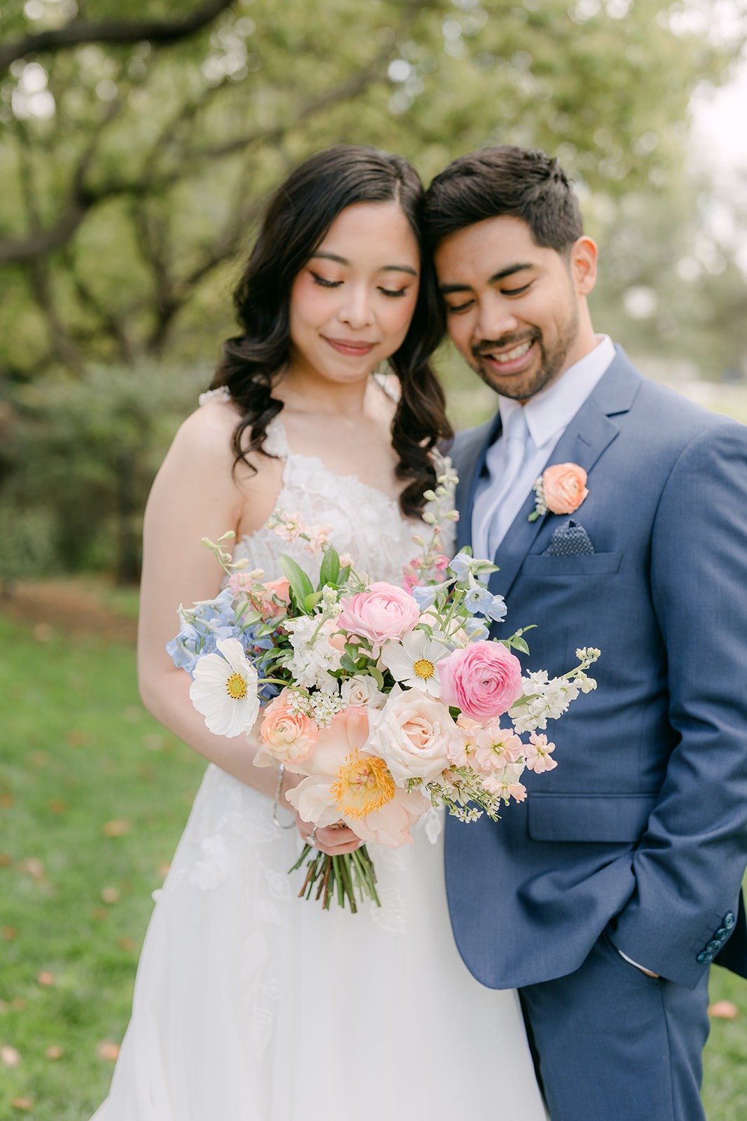 Natalie and Mark cheek to cheek with her pastel bouquet