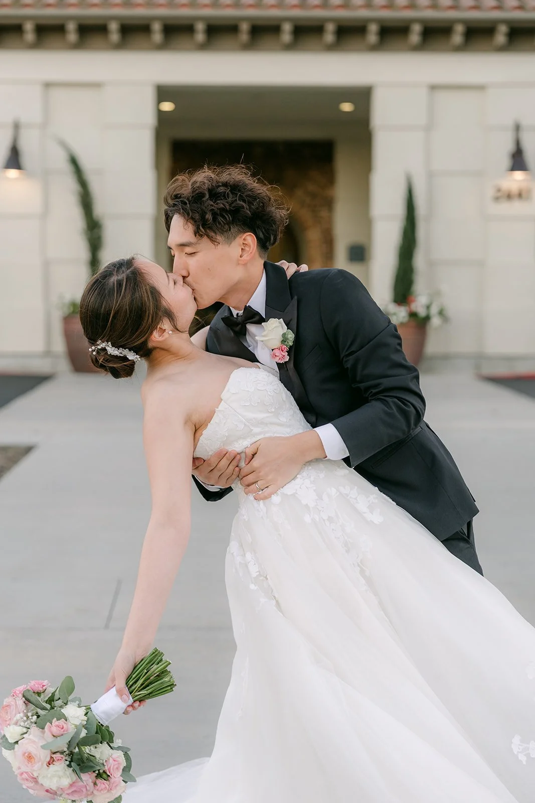 Groom dipping the bride for a kiss at the estate entrance