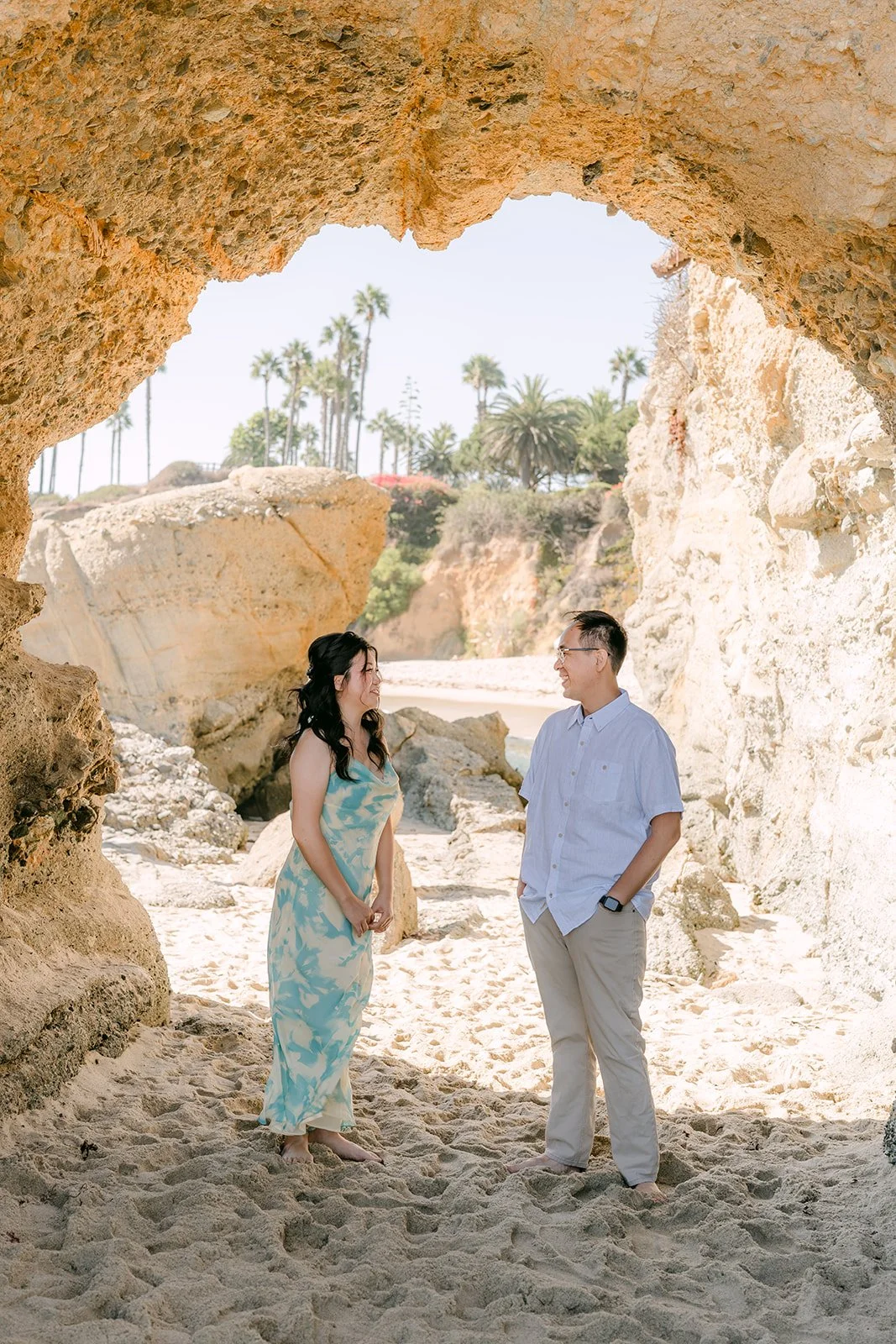 Constance and Lawrence standing under the sandstone rock arch at Treasure Island Beach.