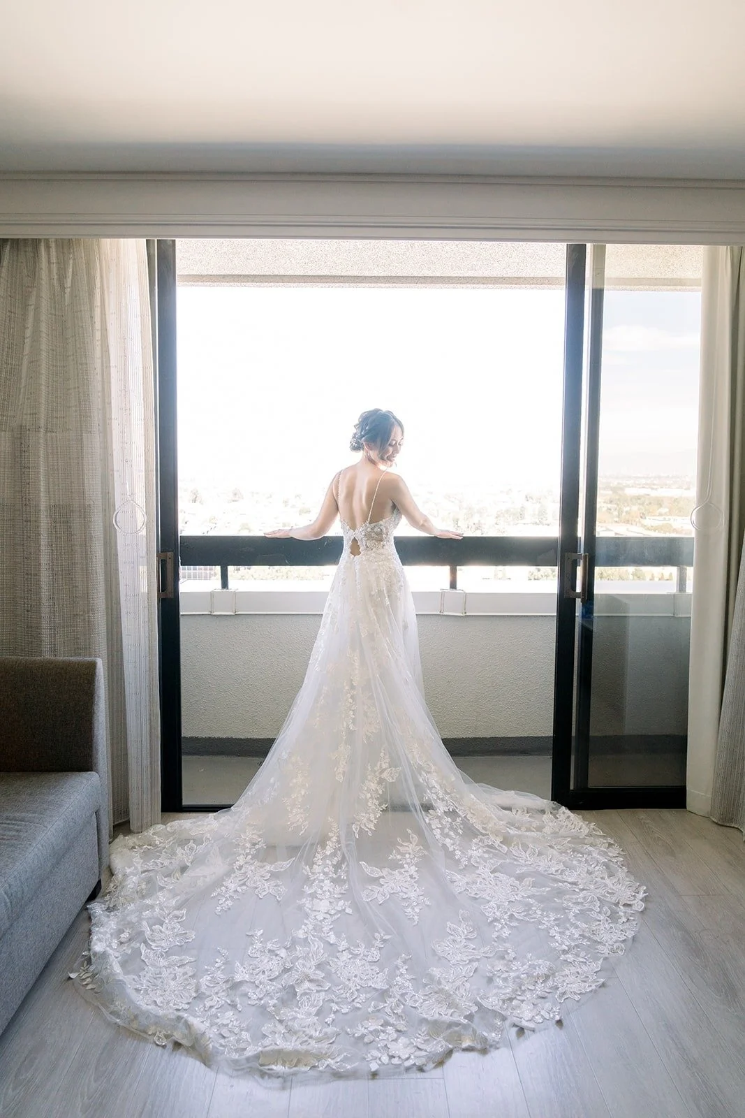 Josephine in her gown by the window with her long train spread across the floor