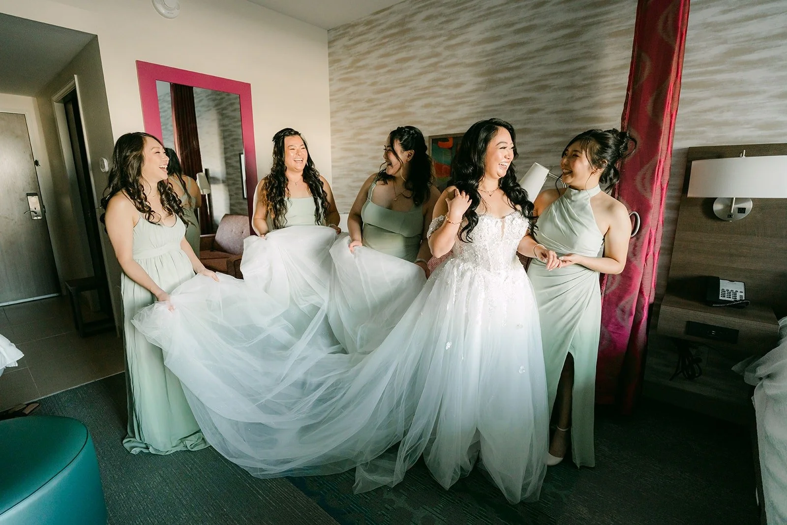 Jennifer's bridesmaids in sage green help with her long train