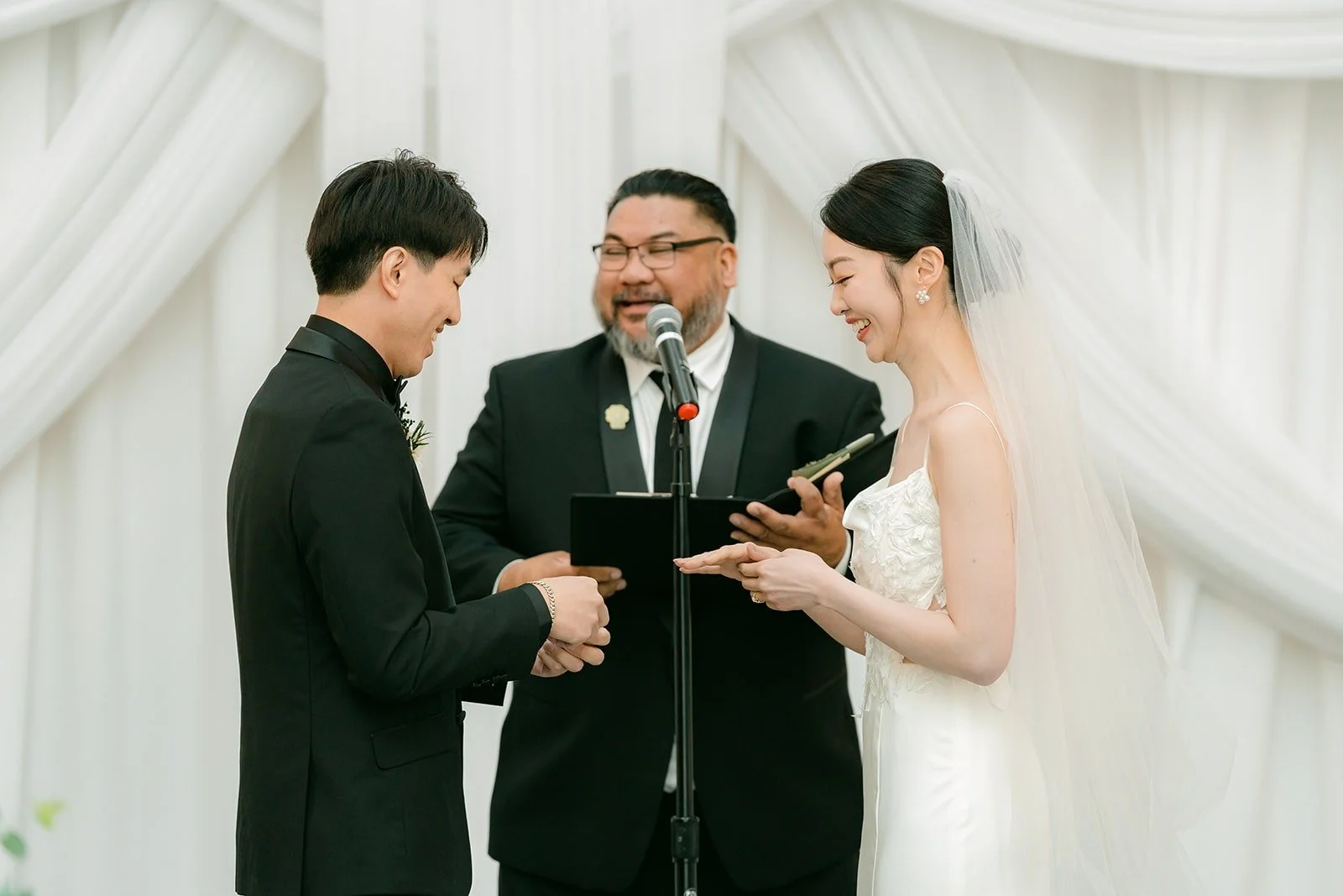 Tin and Fong with the officiant under the white drapes