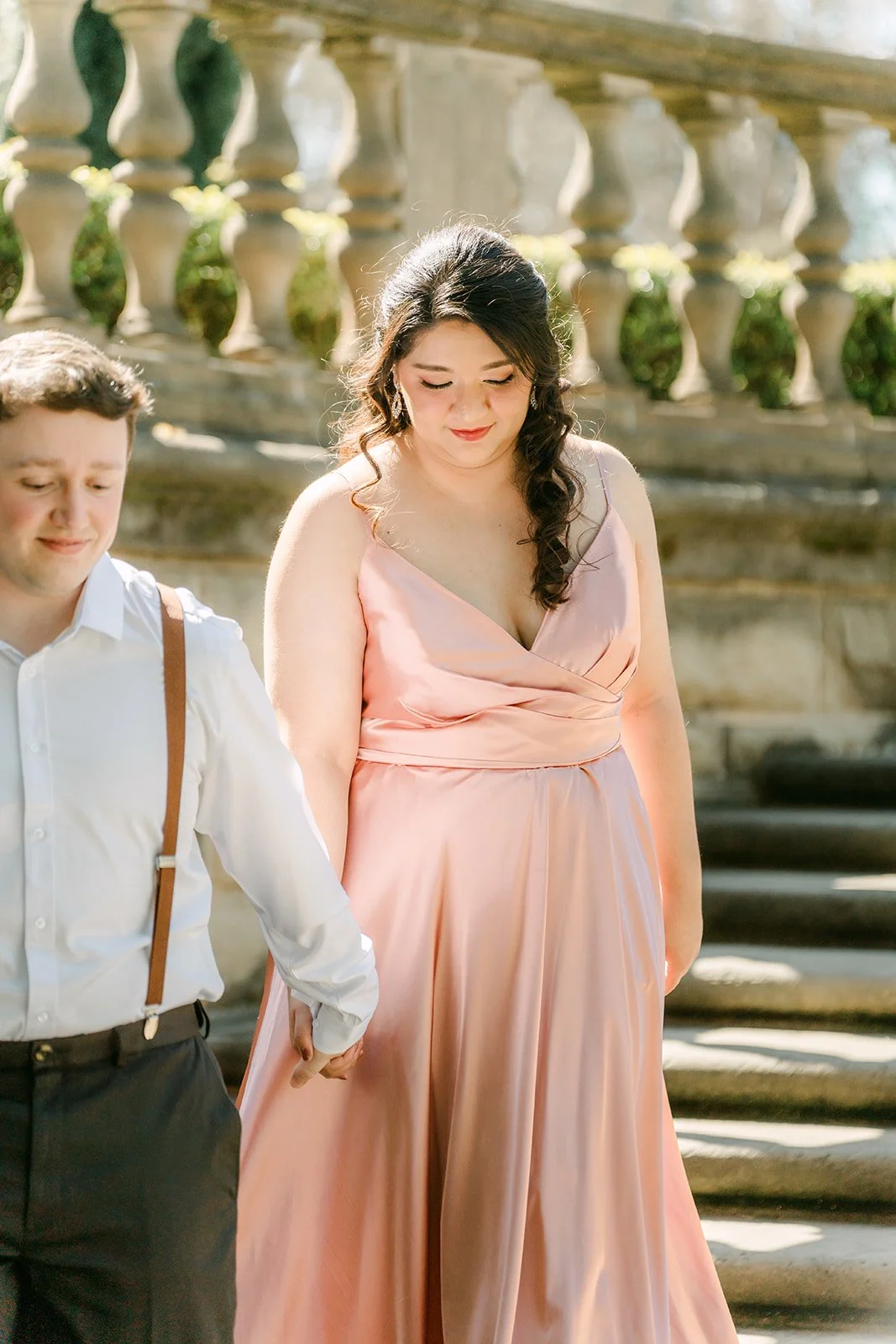 Matthew in brown suspenders walks Saira up the garden staircase.