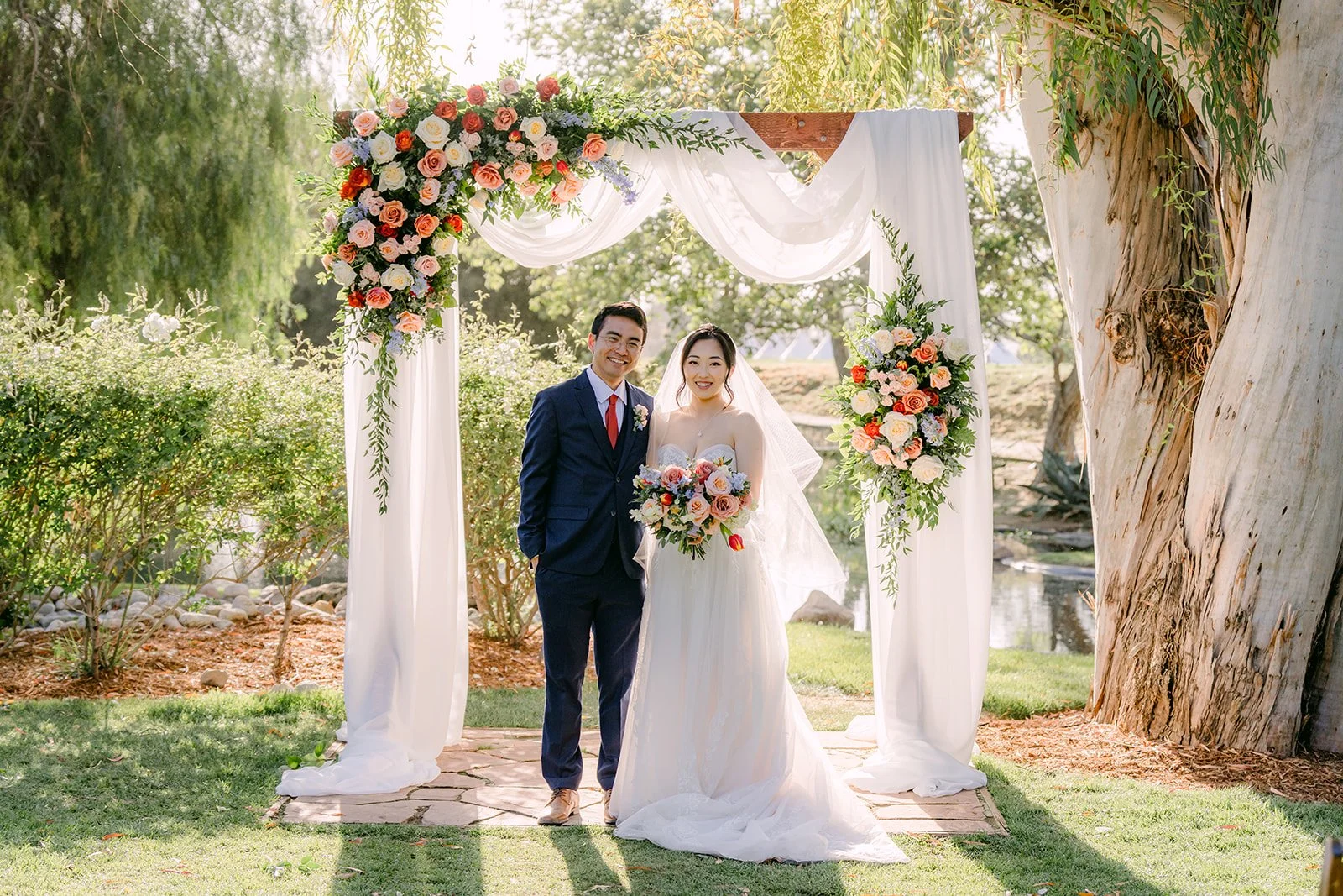 Couple under the white draped floral arch at Galway Downs in Temecula
