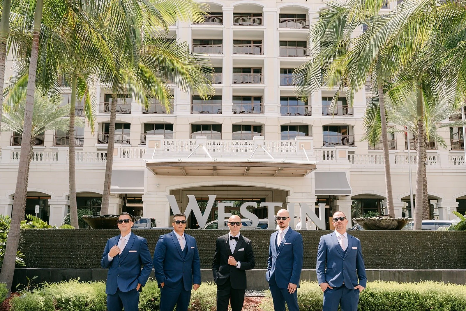 Daniel and his groomsmen in navy suits in front of The Westin Anaheim Resort sign