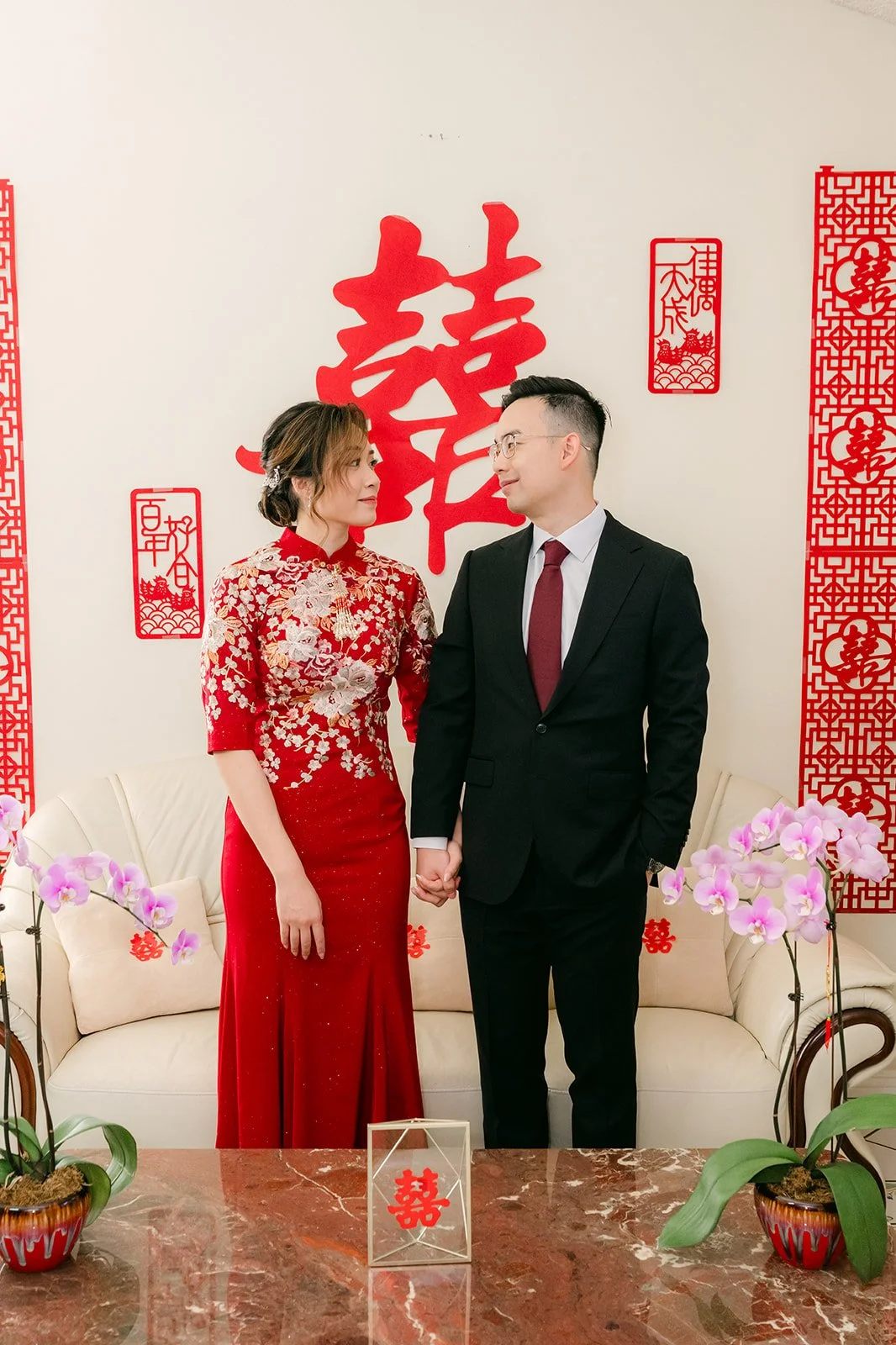 Pauline and Ken in front of red couplets.