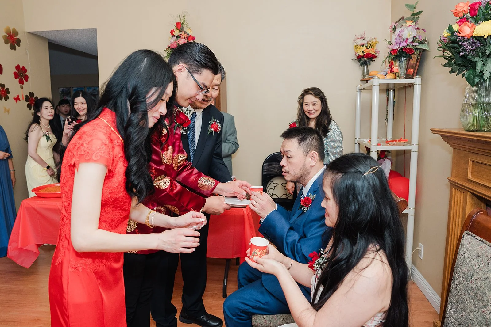 Valerie and Danny serving tea to relatives on the sofa.