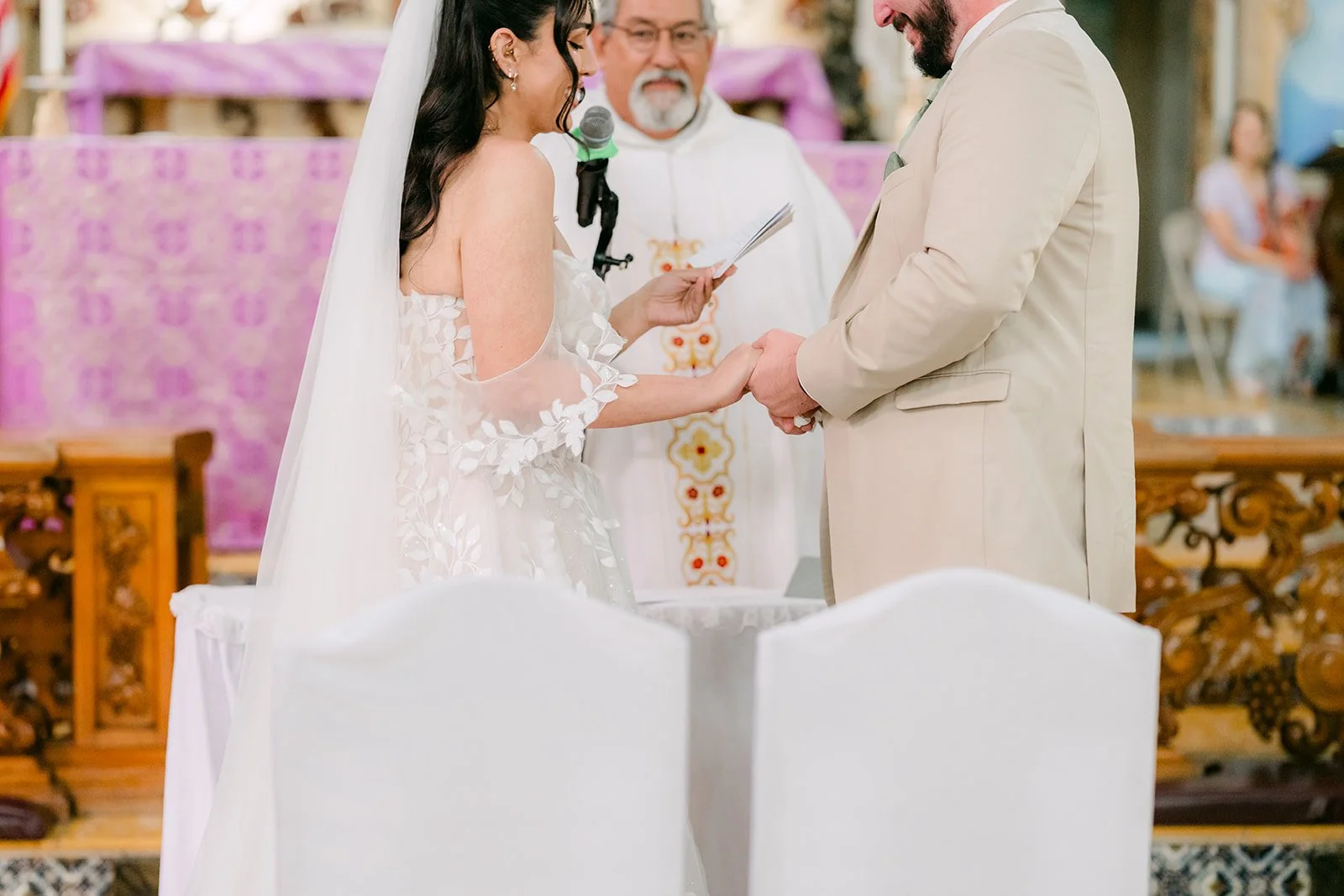 Fernanda and Cody holding hands at the altar.