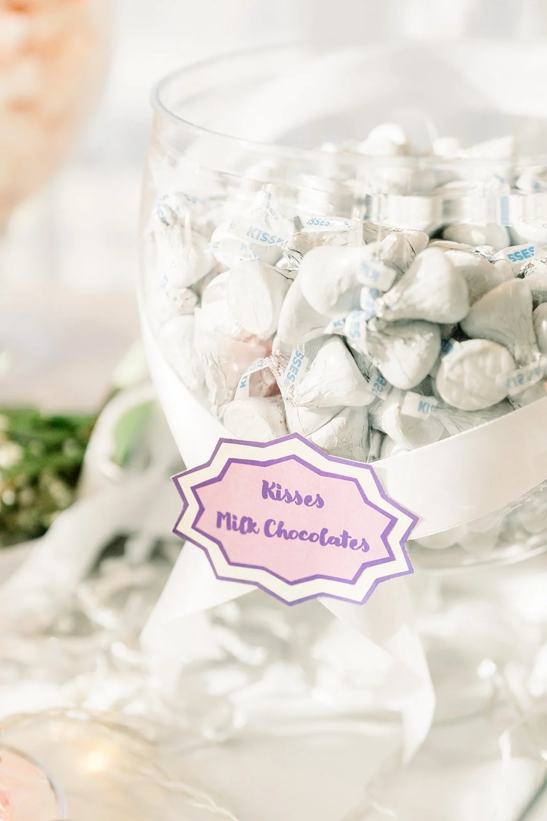 Silver wrapped chocolates in a glass jar as wedding favors