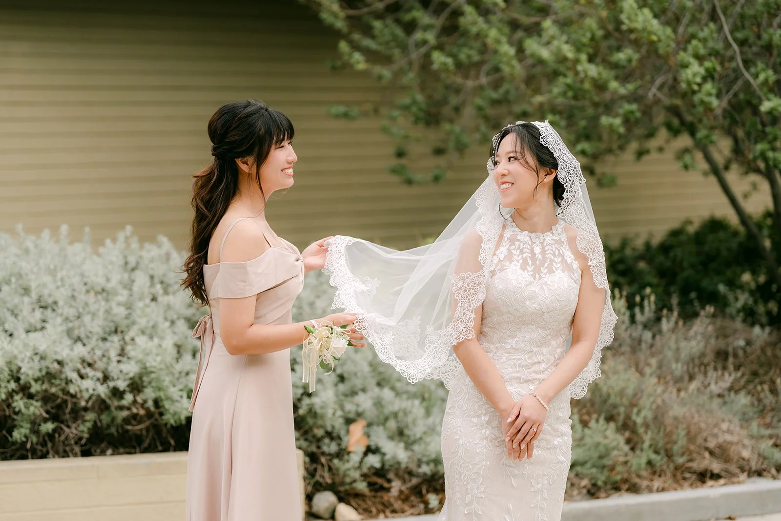 Kathleen adjusting Elaine's veil outside.