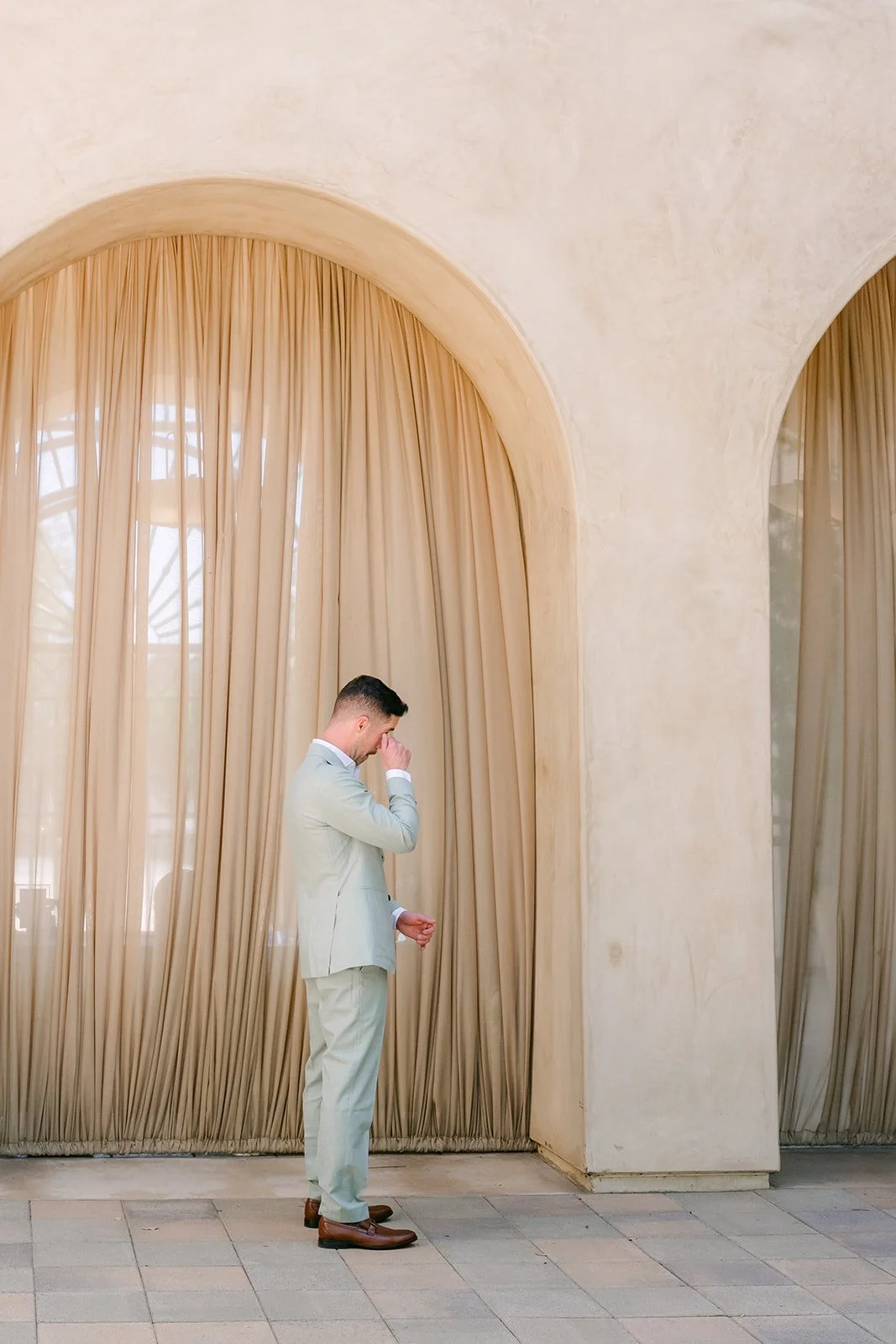 Anthony waiting under a curtained arch before the first look